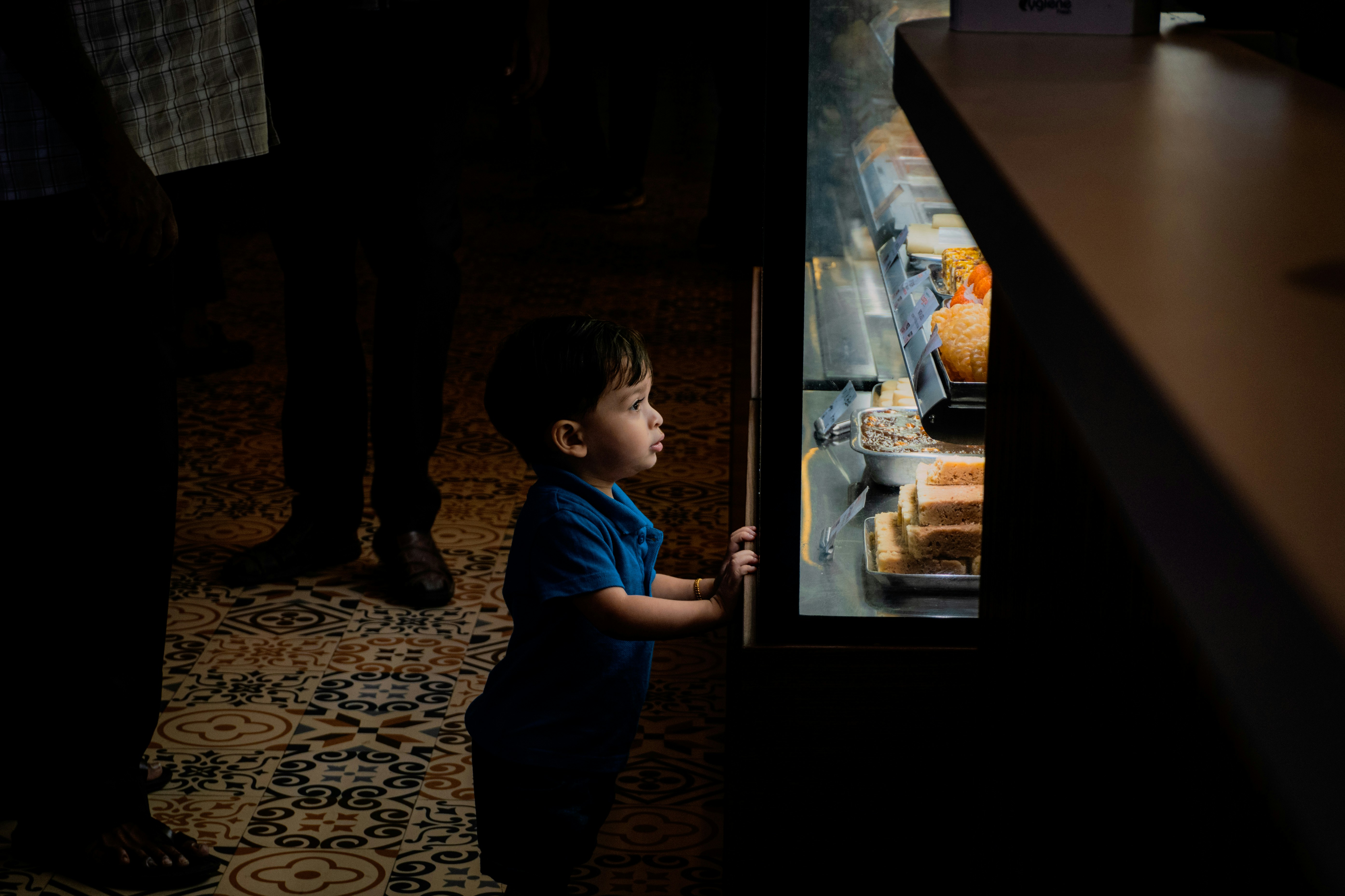 A young child looks into a brightly lit display case.