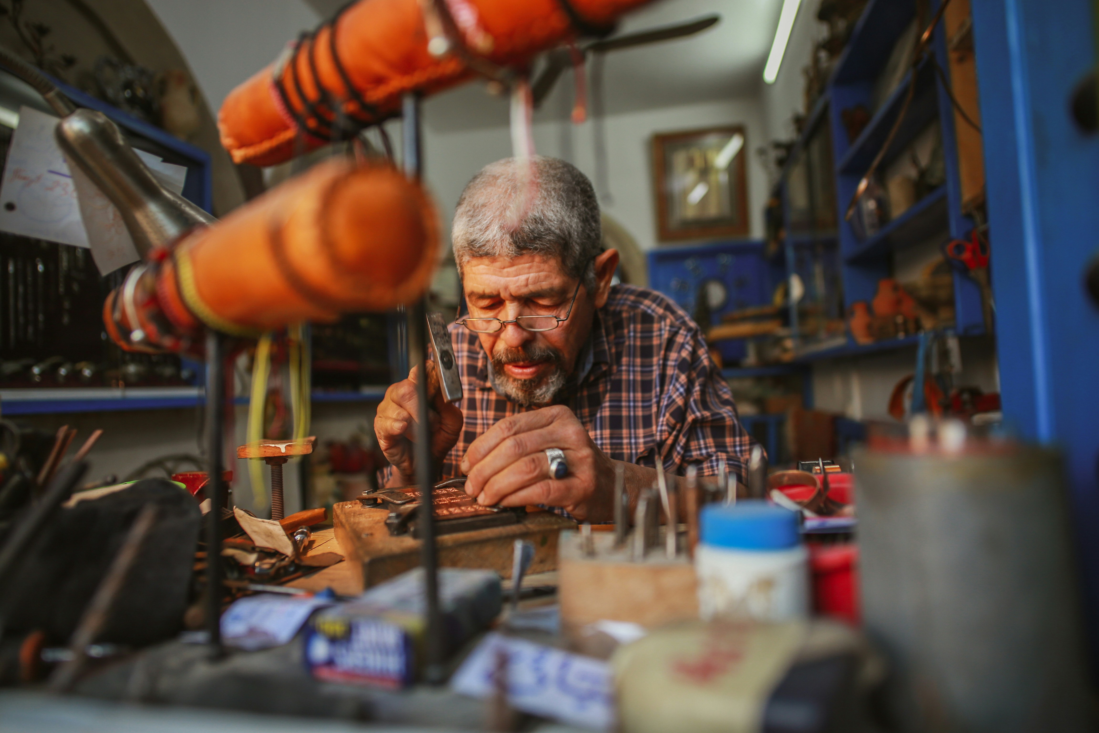 A man crafts souvenirs in Djerbahood, located in Djerba, Tunisia, which carries deep traces of history with its narrow streets, traditional architecture, and historic buildings, captivating its visitors on May 02, 2026.