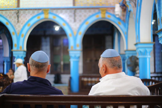 Two men wearing kippahs in a synagogue