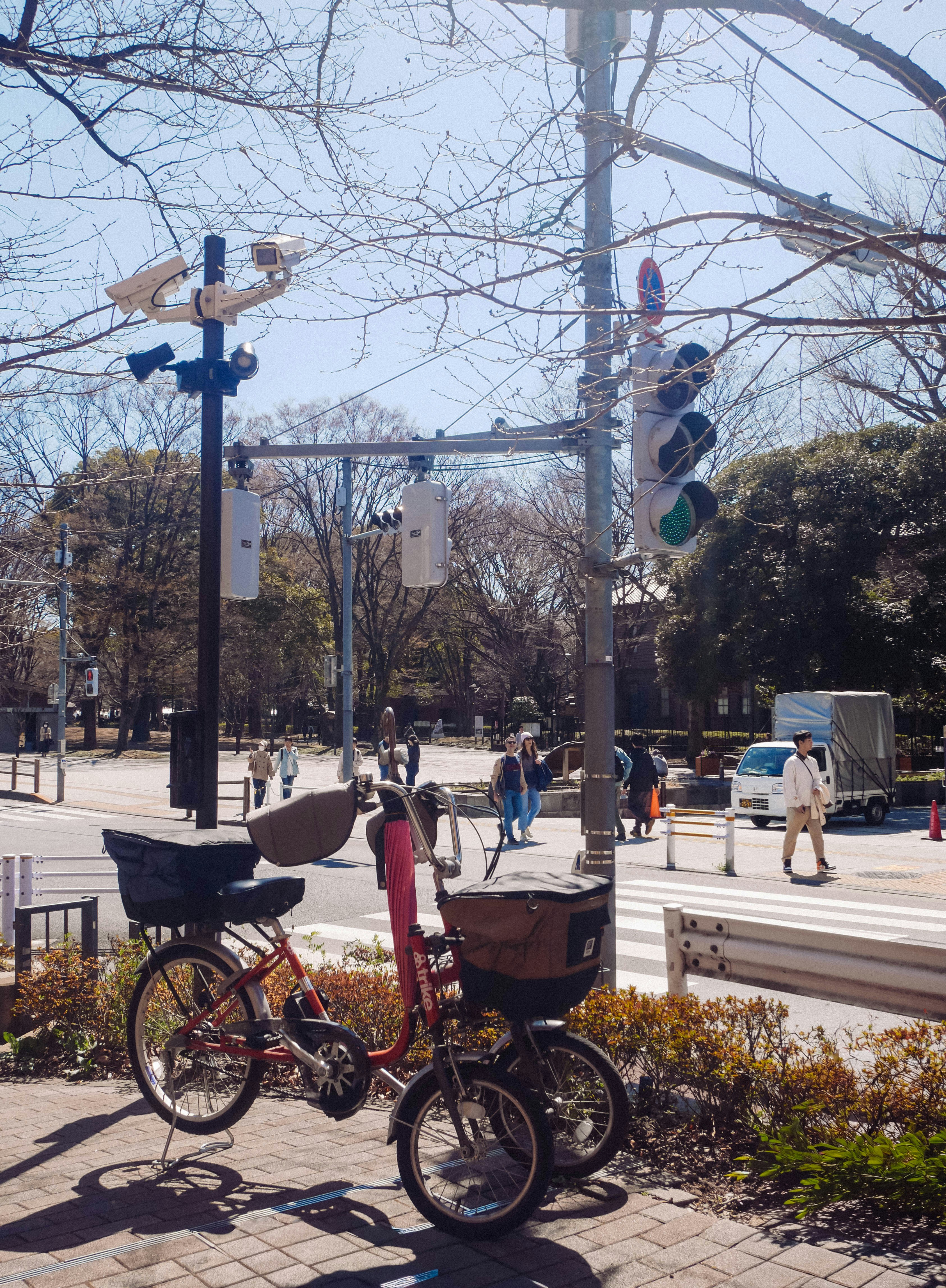 Two bicycles parked near a street intersection with traffic lights