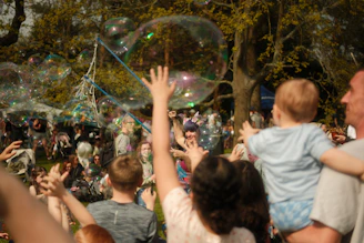Children reaching for large bubbles at an outdoor event