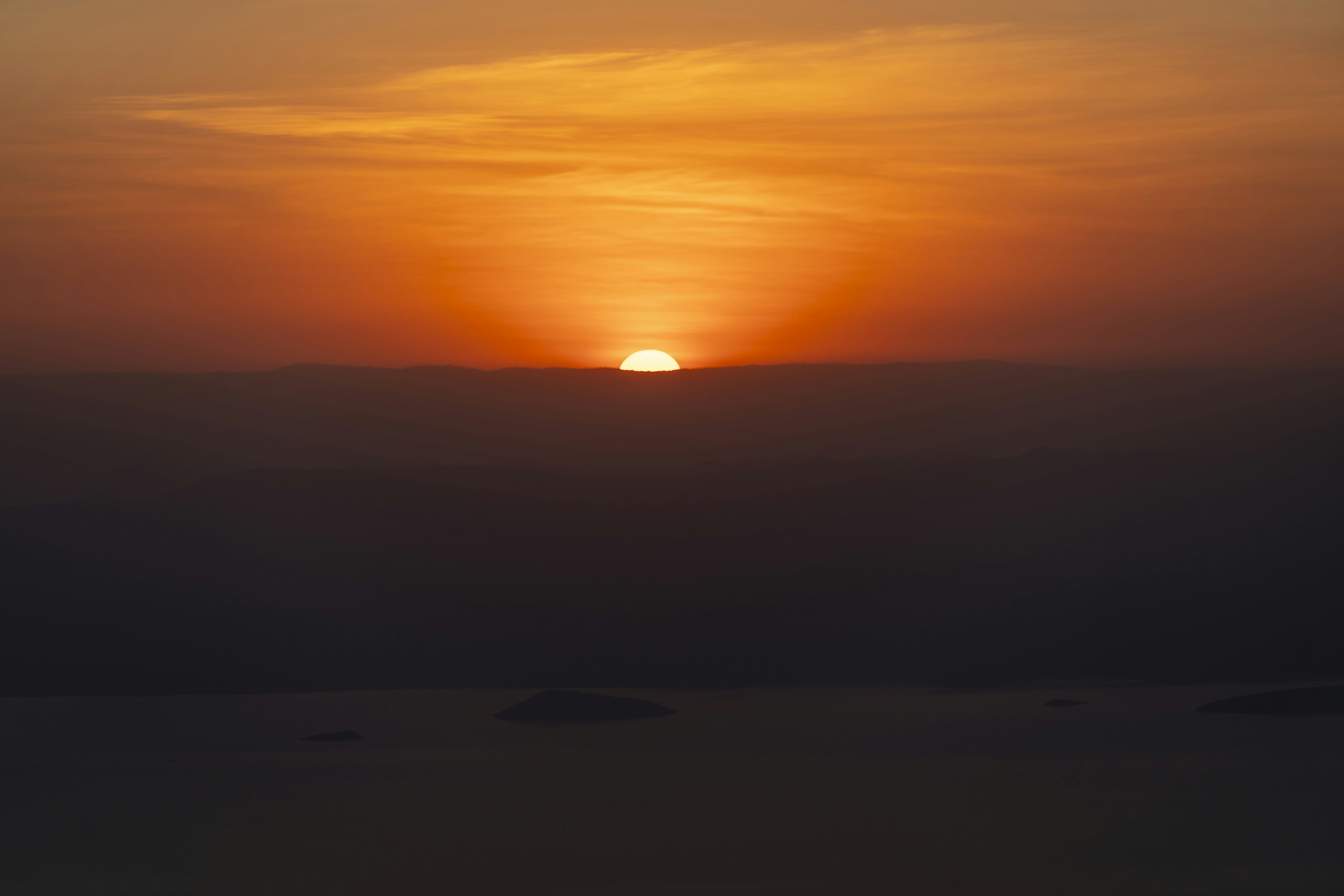 Die Sonne, die über einem nebligen Horizont untergeht.