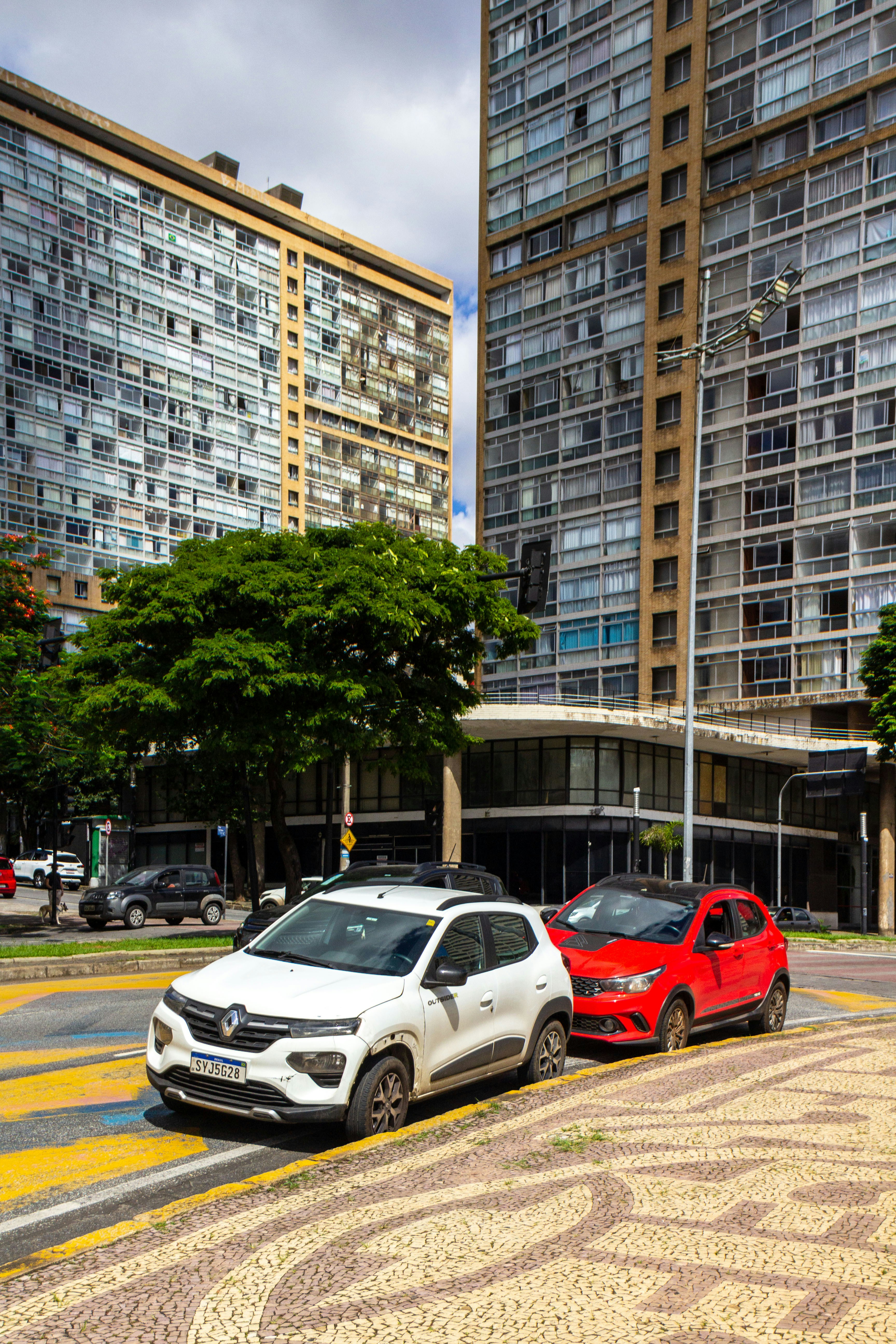 Zwei Autos parkten auf einer Stadtstraße in der Nähe von Gebäuden.