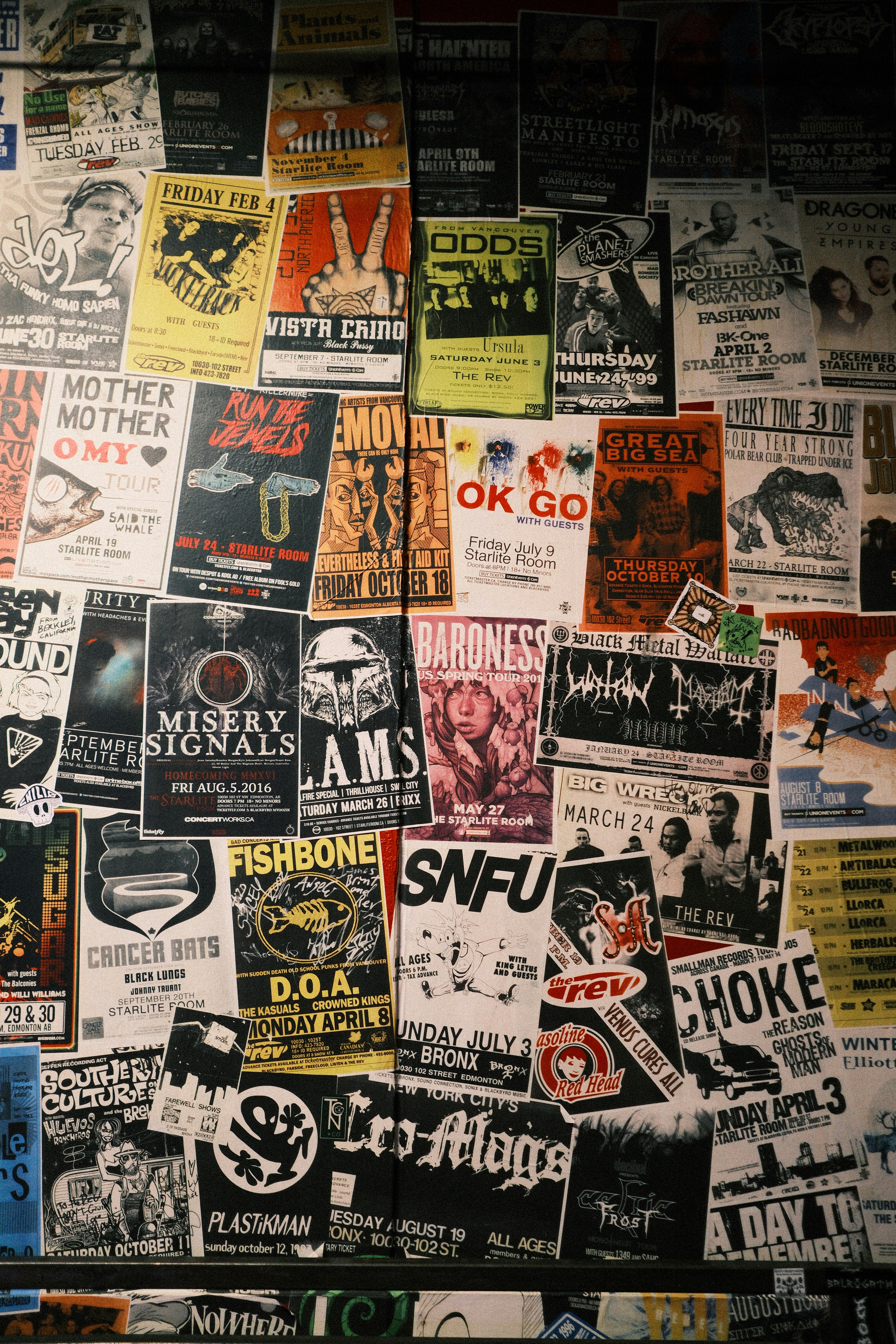 Collage de carteles de conciertos y folletos vintage en la pared.