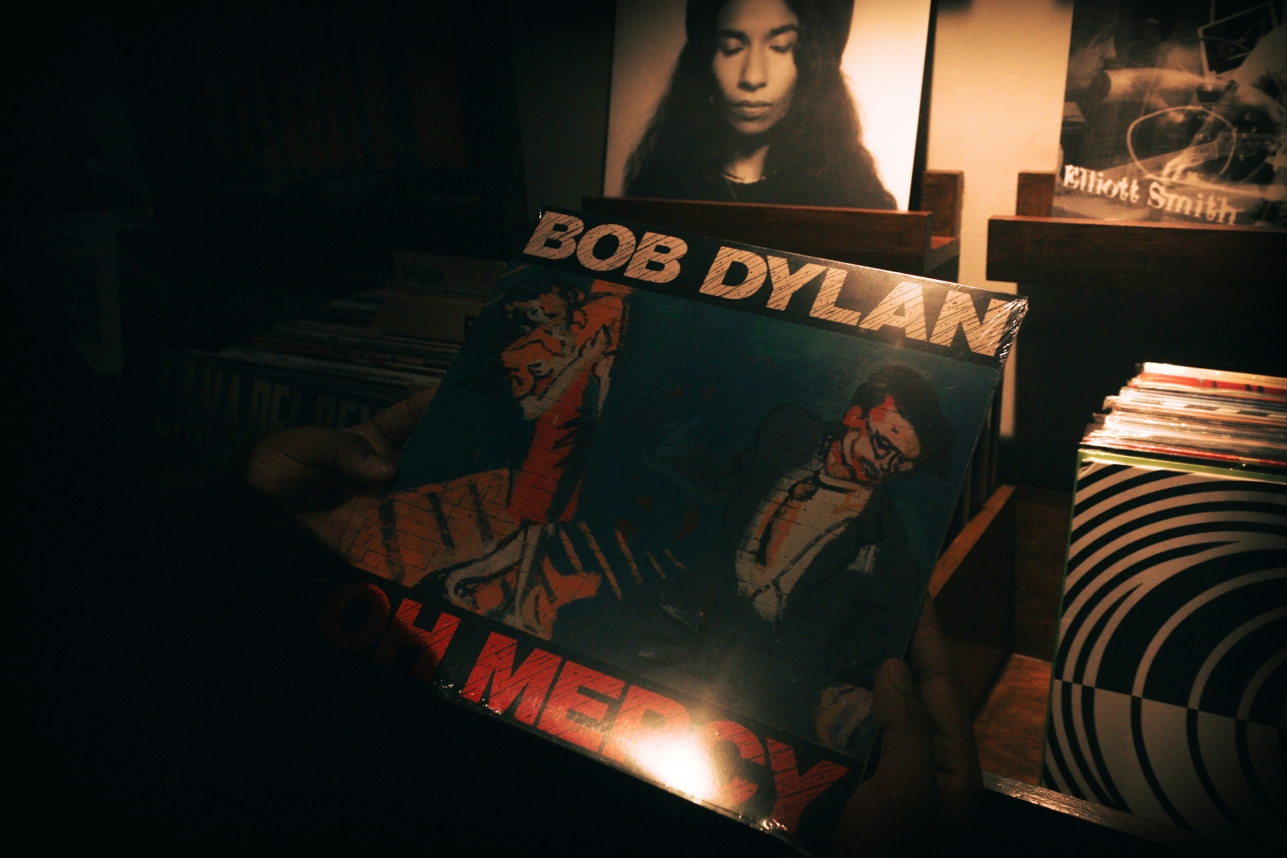 Bob dylan album cover held in a dimly lit room
