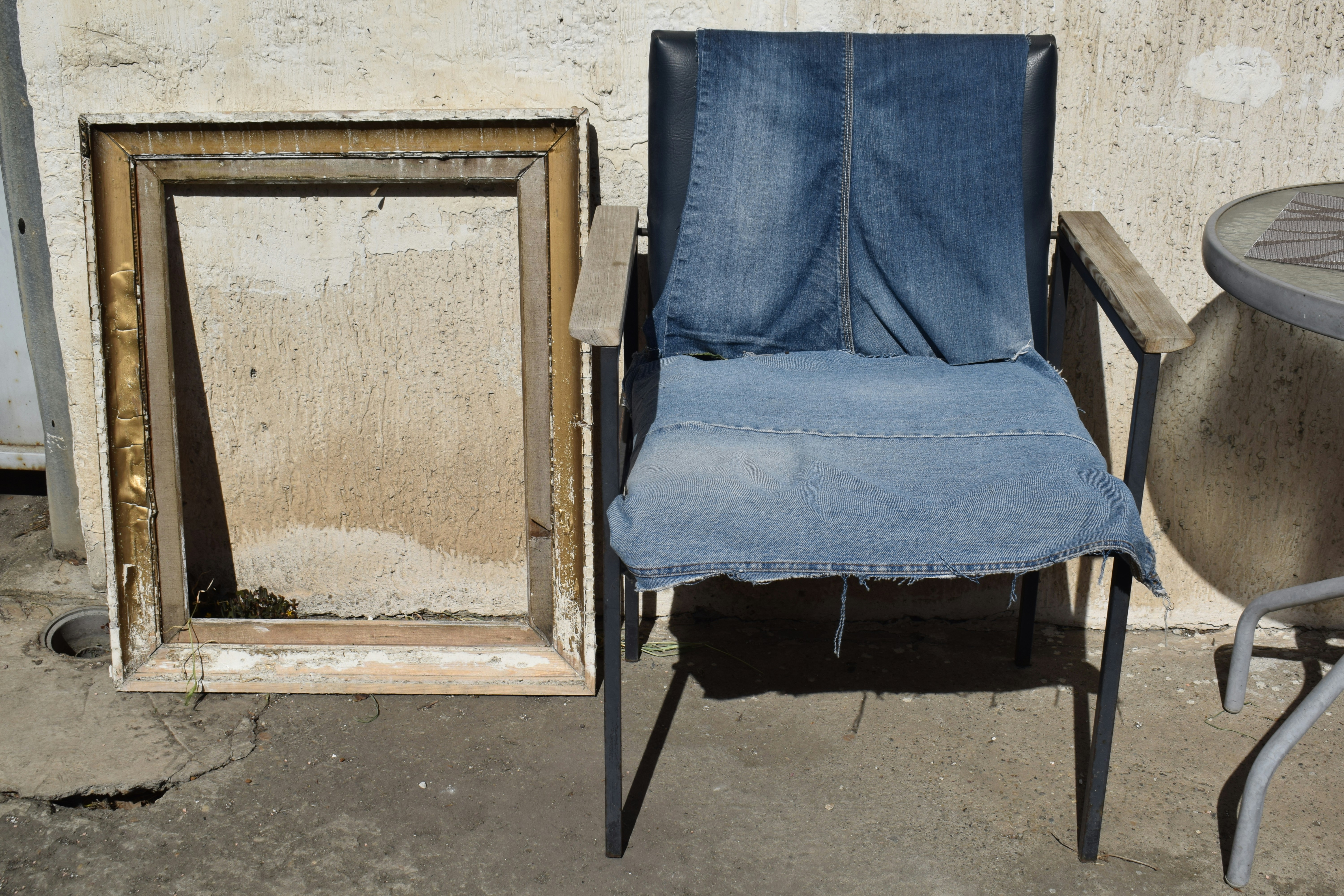 Chair with denim seat next to empty frame
