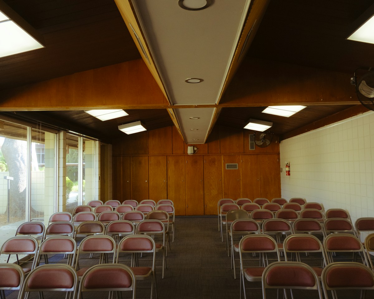 Rows of empty chairs in a wood-paneled room, ready for a holiday volunteer sign-up event.