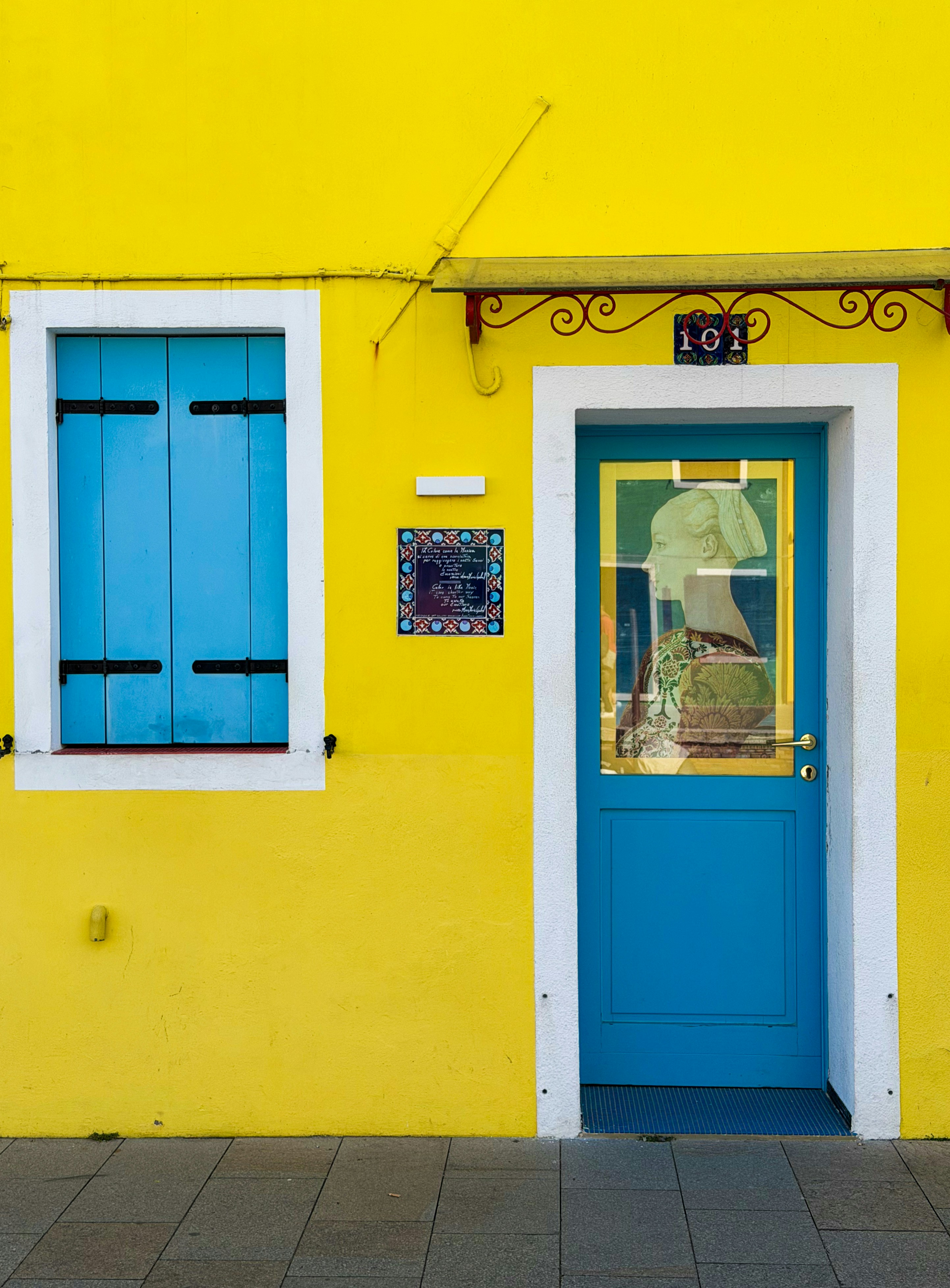 Bâtiment jaune vif avec porte et fenêtre bleues