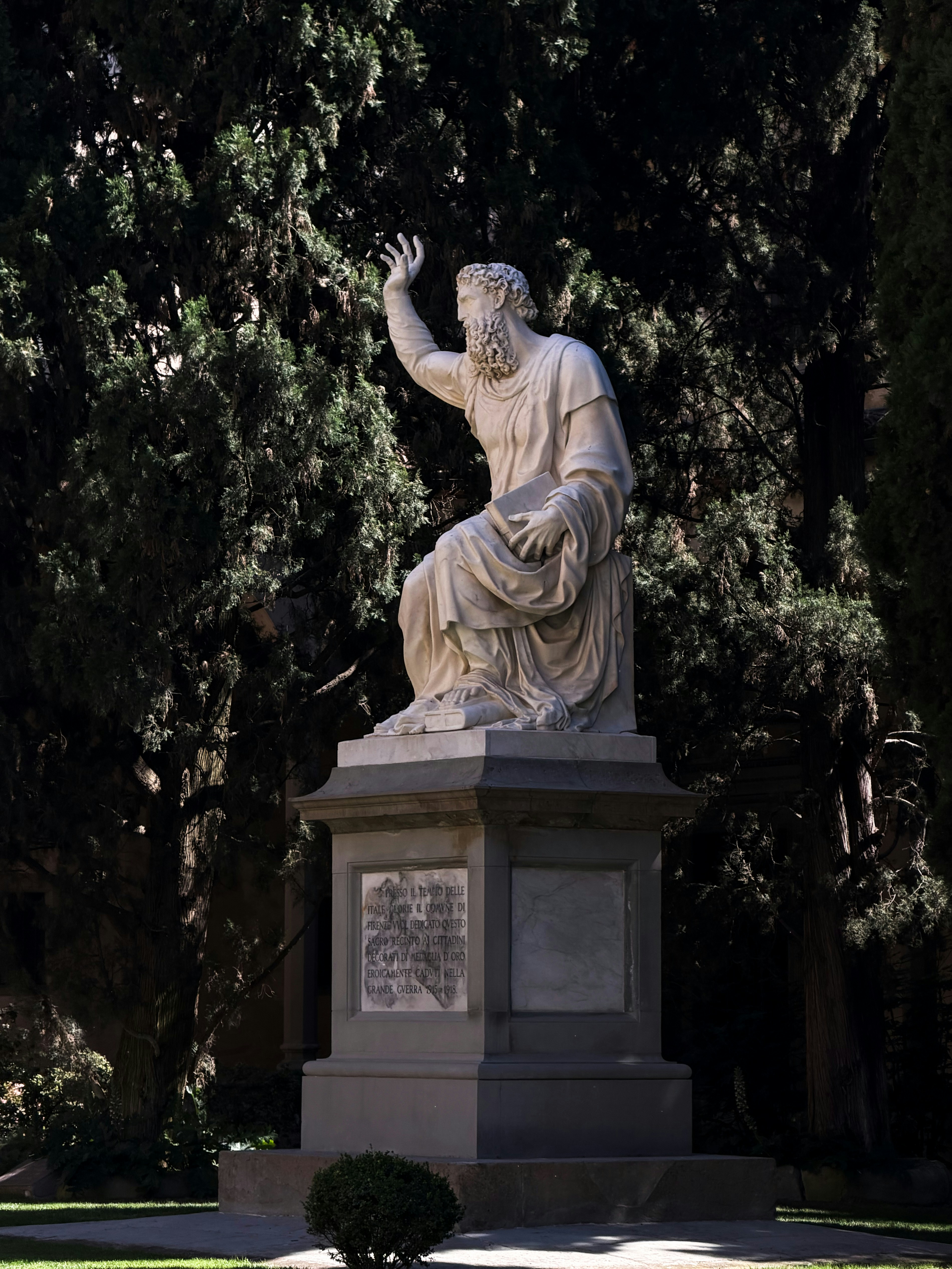 Statue en marbre d’un homme en robe avec la main levée.