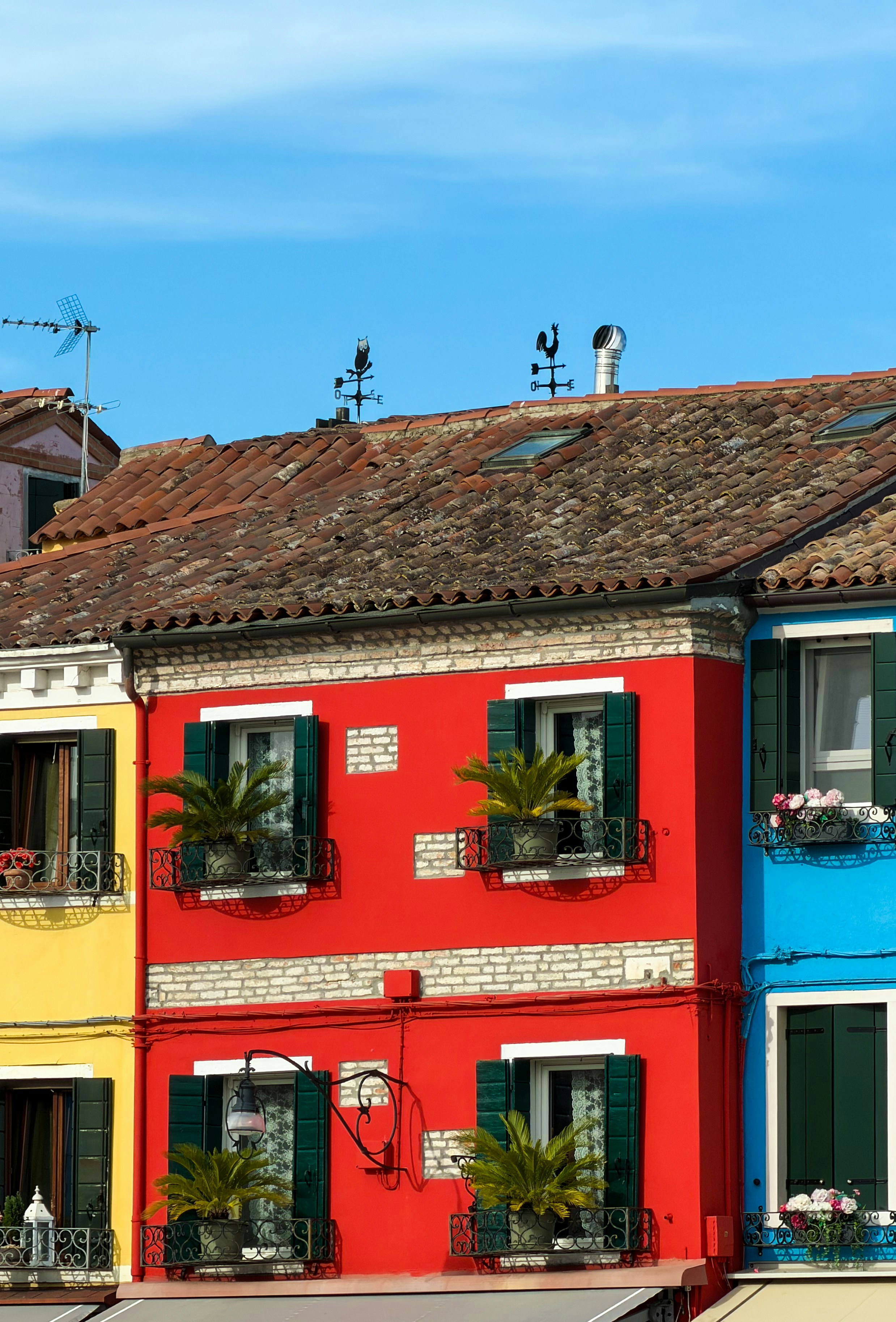 Des bâtiments colorés aux fenêtres ouvertes sous un ciel bleu