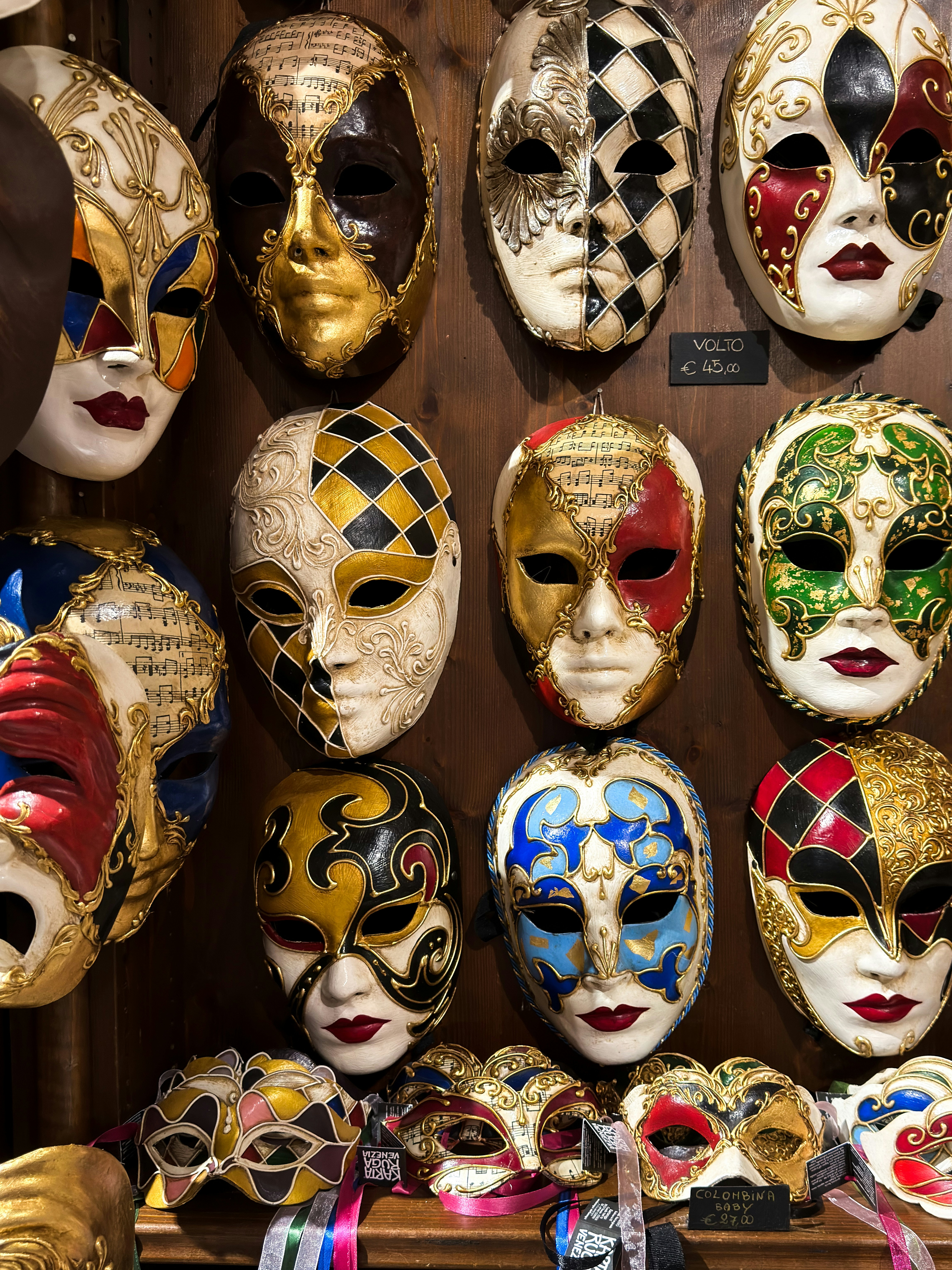 Collection de masques vénitiens ornés exposés sur un mur
