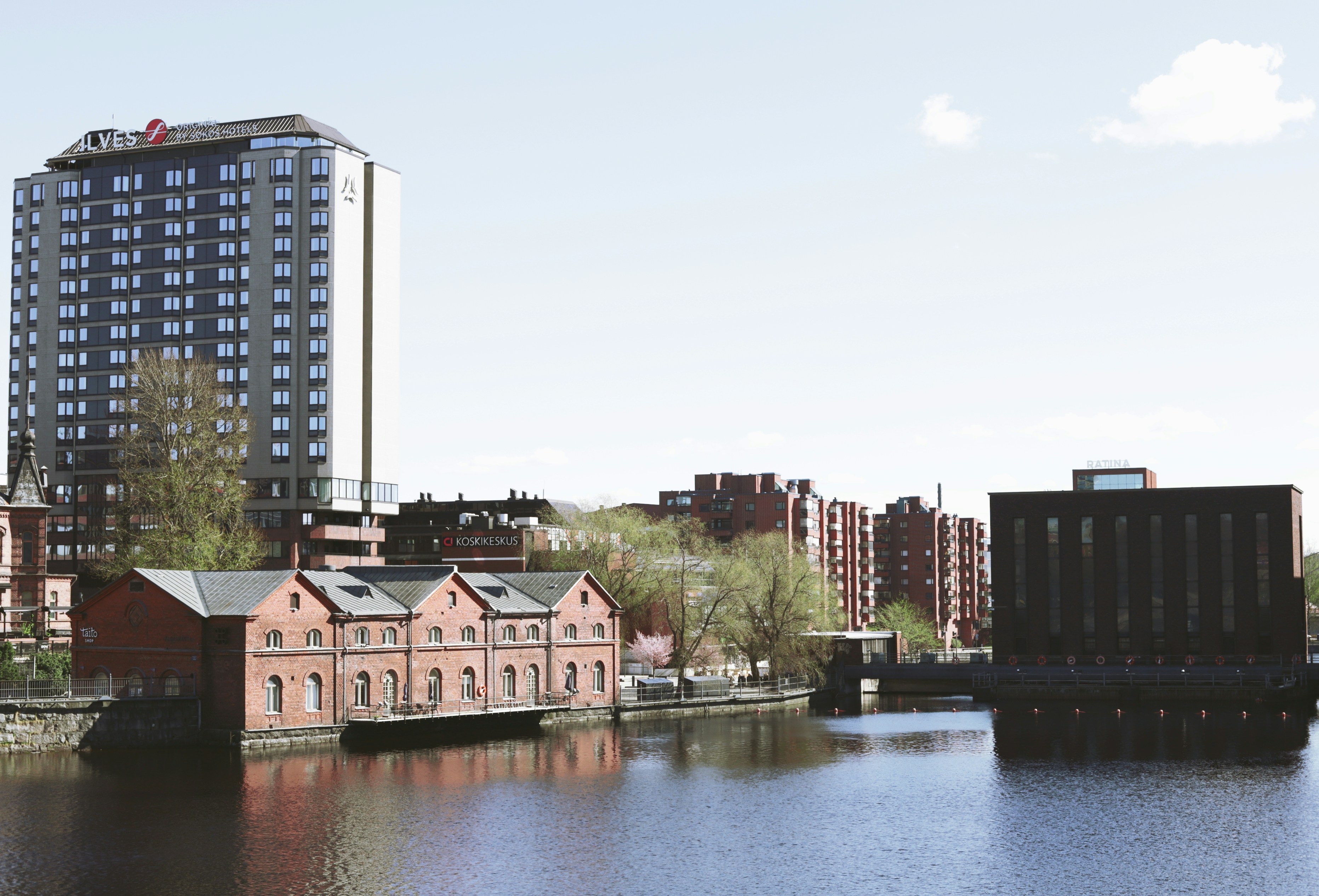 Buildings along a calm river under a clear sky