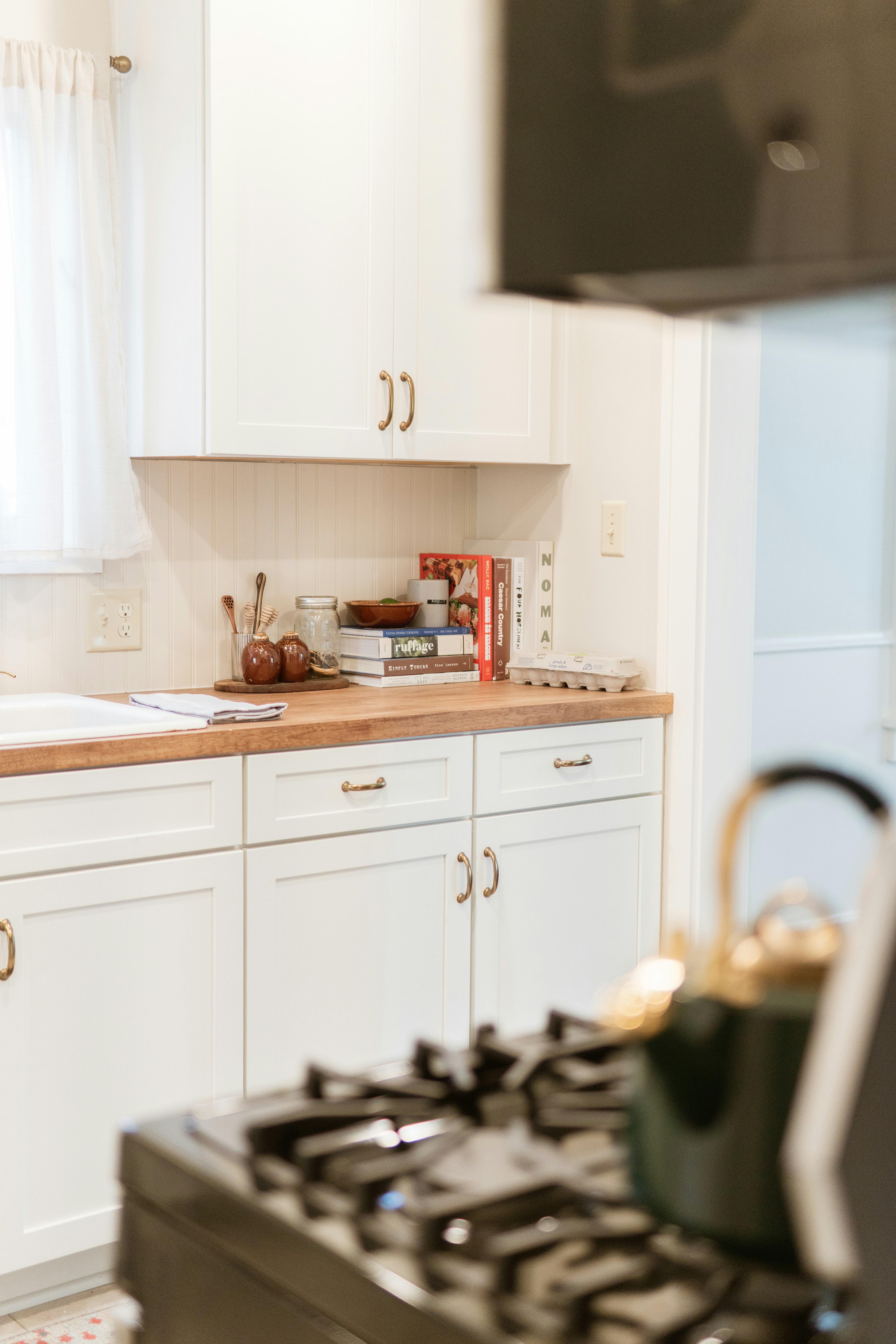 Dapur modern dengan lemari putih dan meja kayu