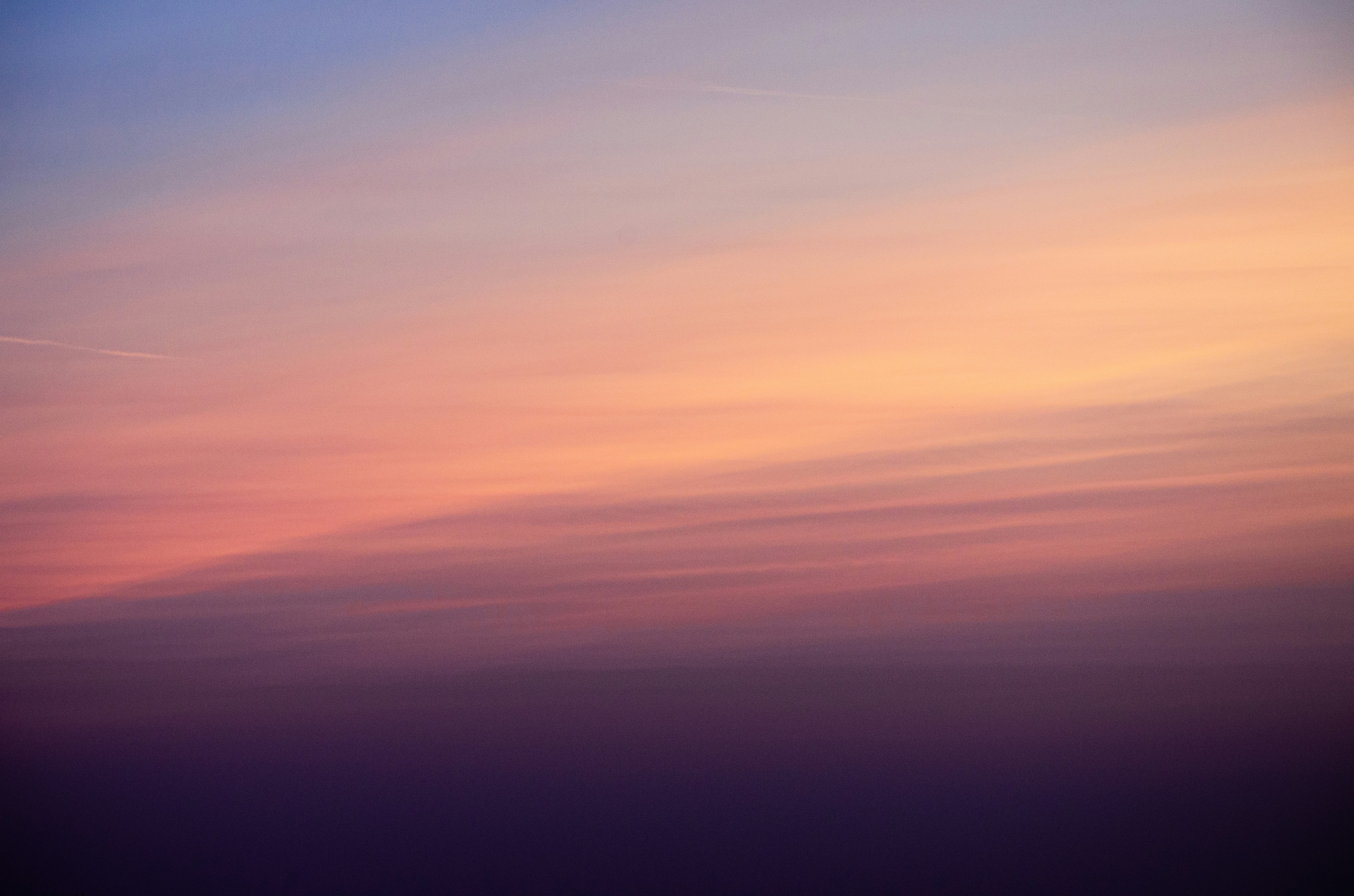 Sanfter pastellfarbener Sonnenuntergangshimmel mit dünnen Wolken.