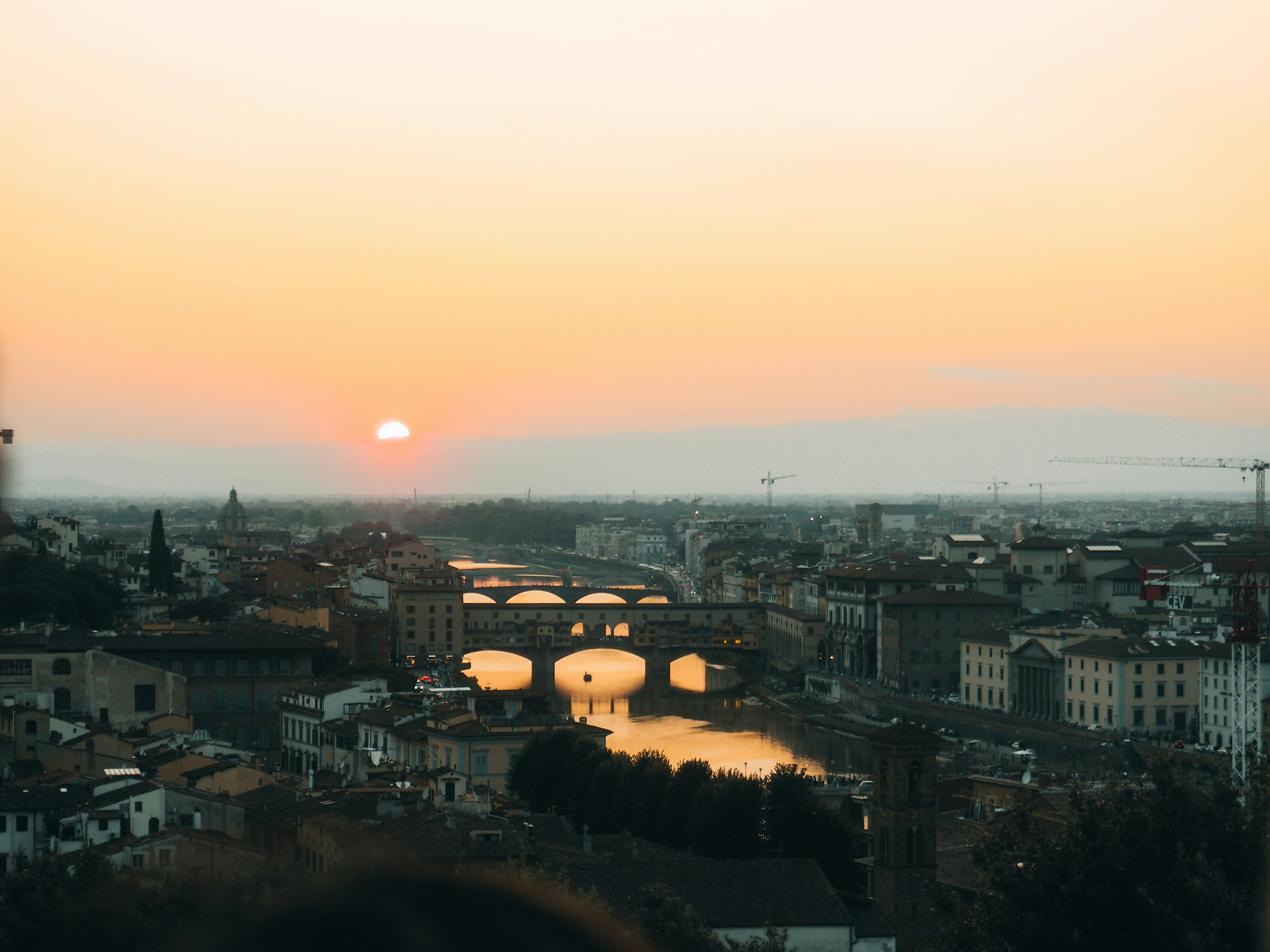 Sunset over a historic european city with a river.