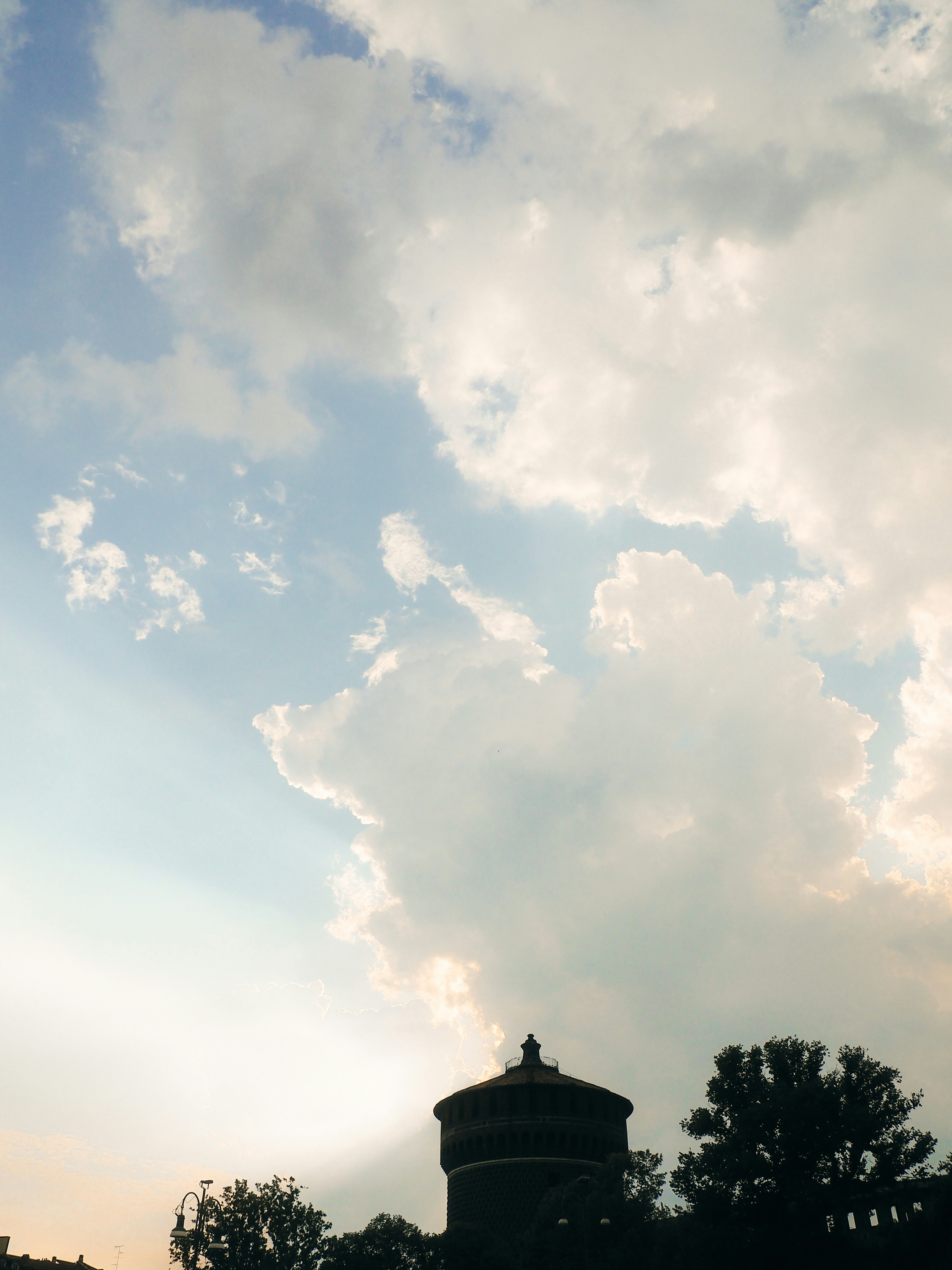 Silhouette of a water tower against a cloudy sky