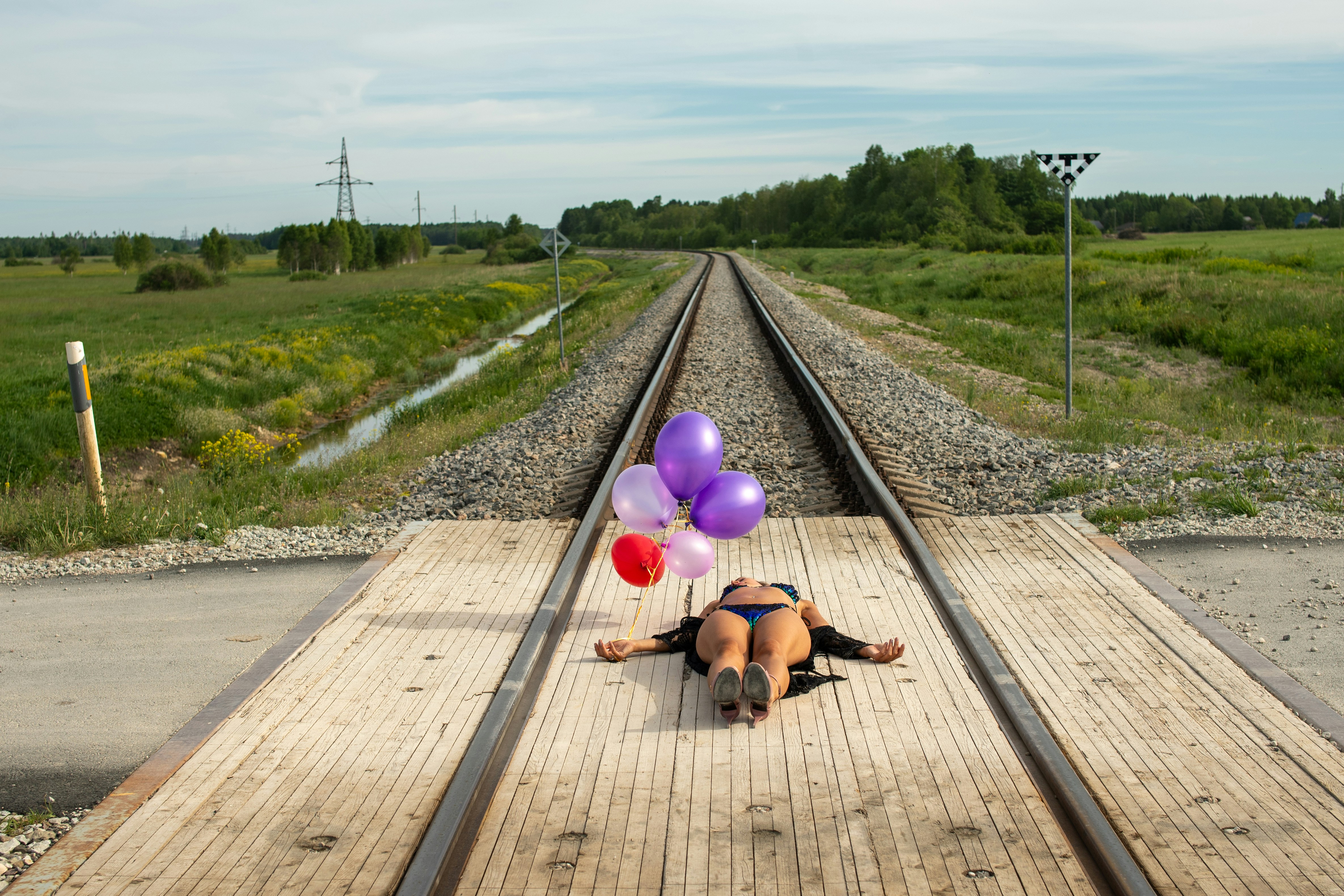 Wanita dengan balon tergeletak di rel kereta api