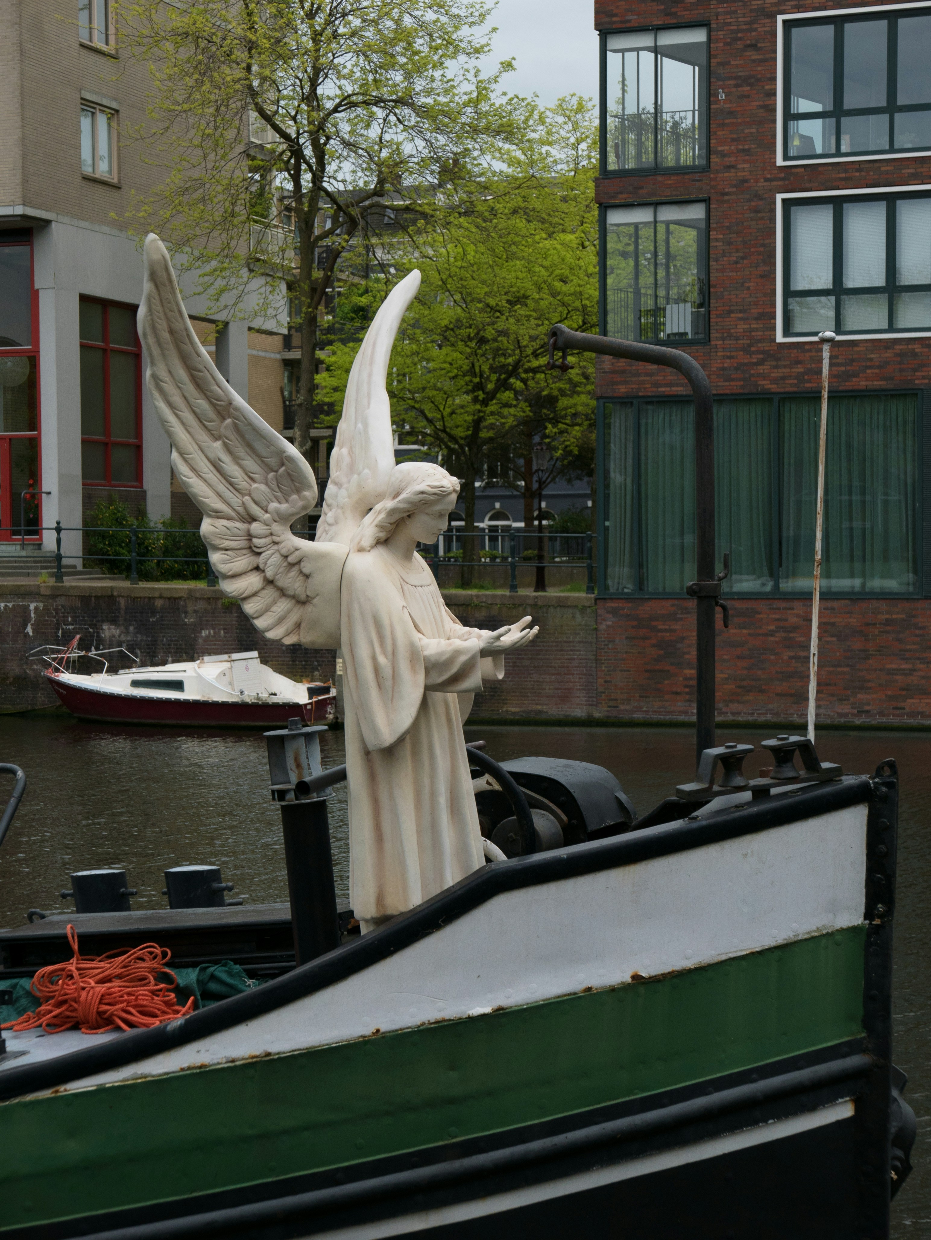 Estátua de anjo em um barco em um canal.