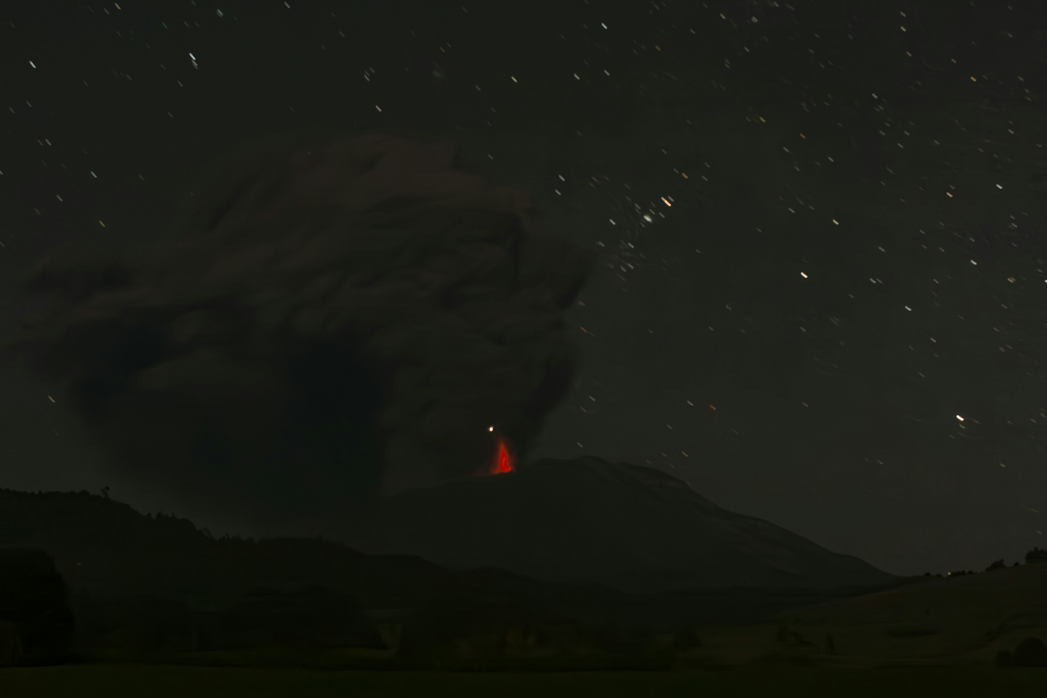 Volcanic eruption under a starry night sky