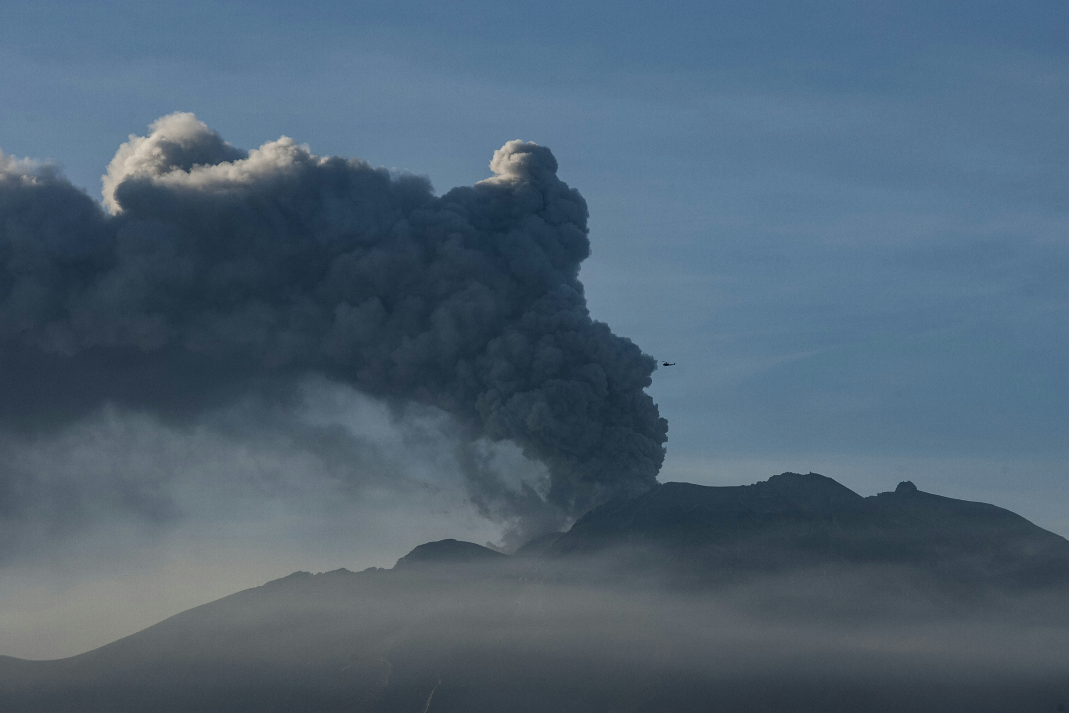 Volcano erupting with a large plume of smoke