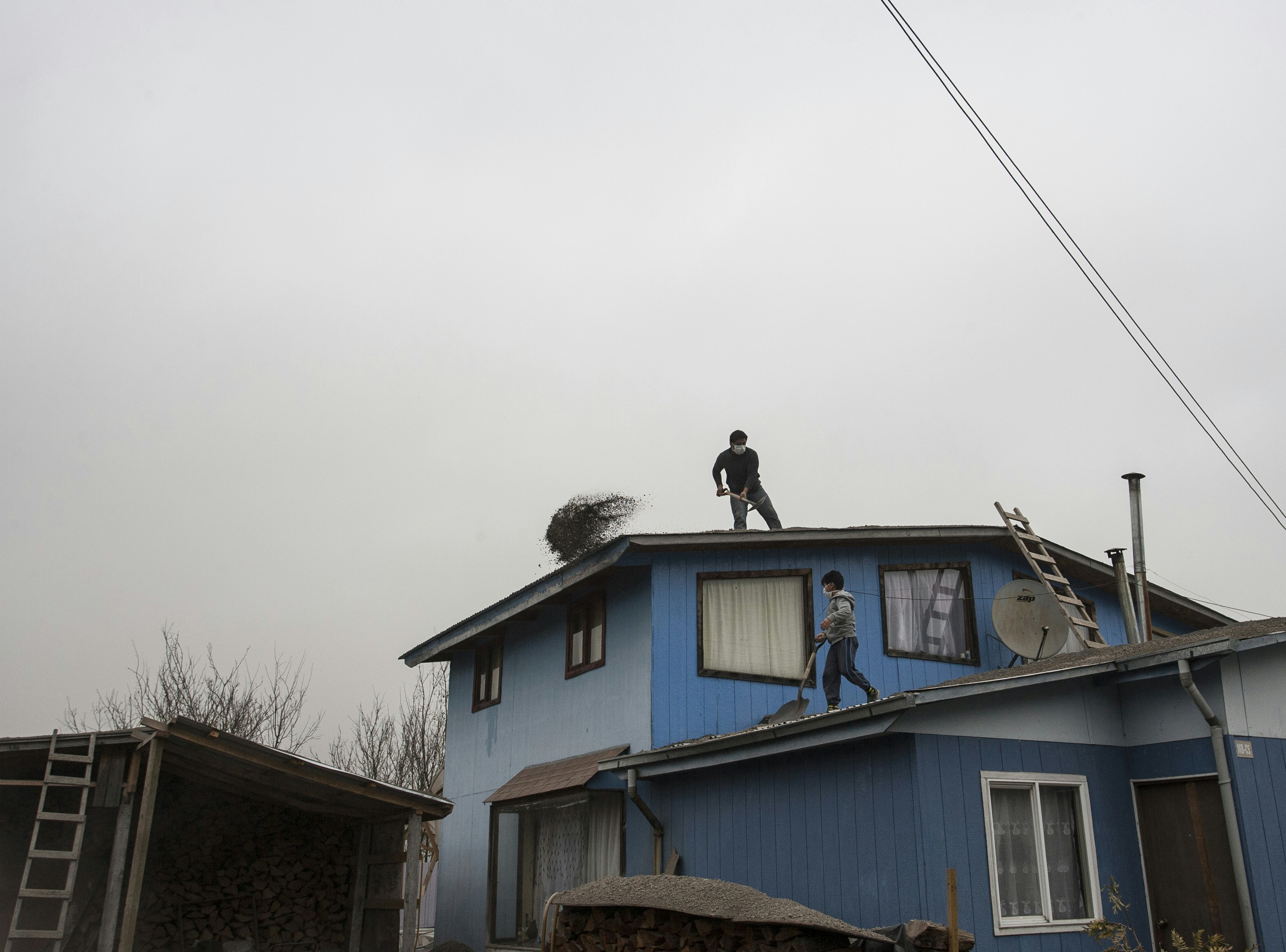 Two people on a blue house roof