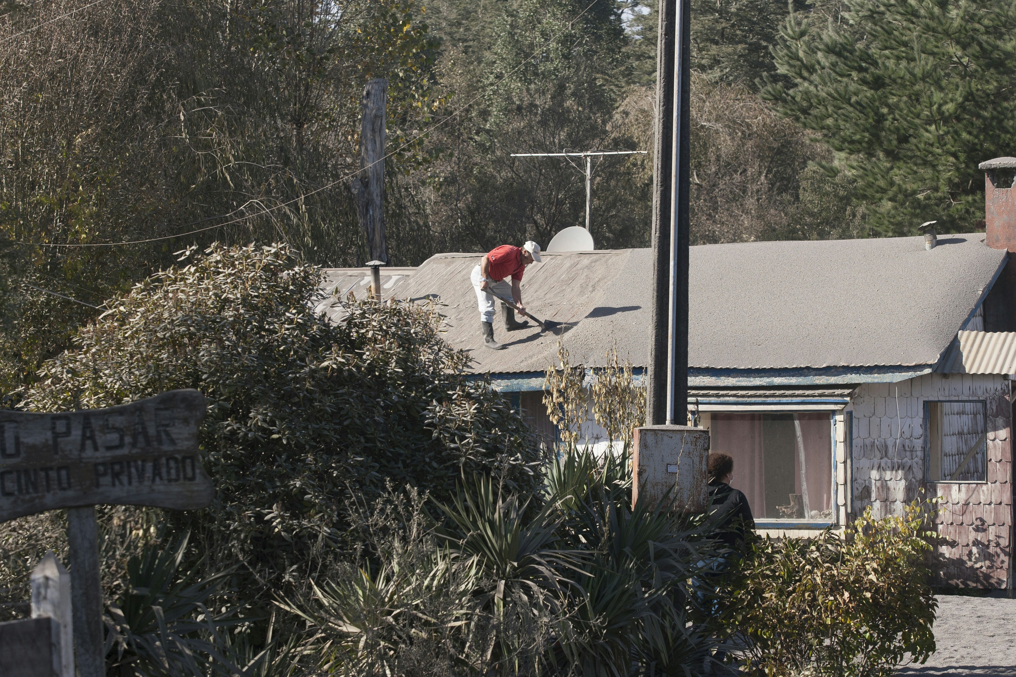 A person works on a roof in a rural setting.