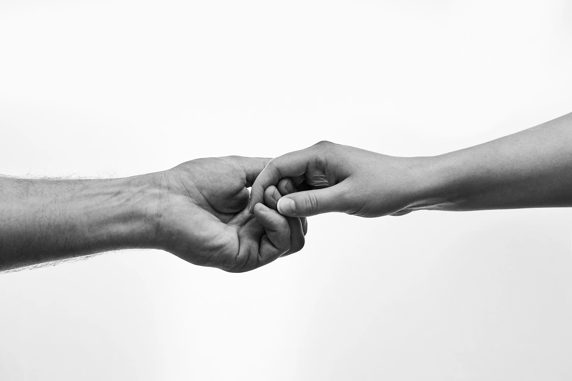 Two hands gently touching fingers against white background