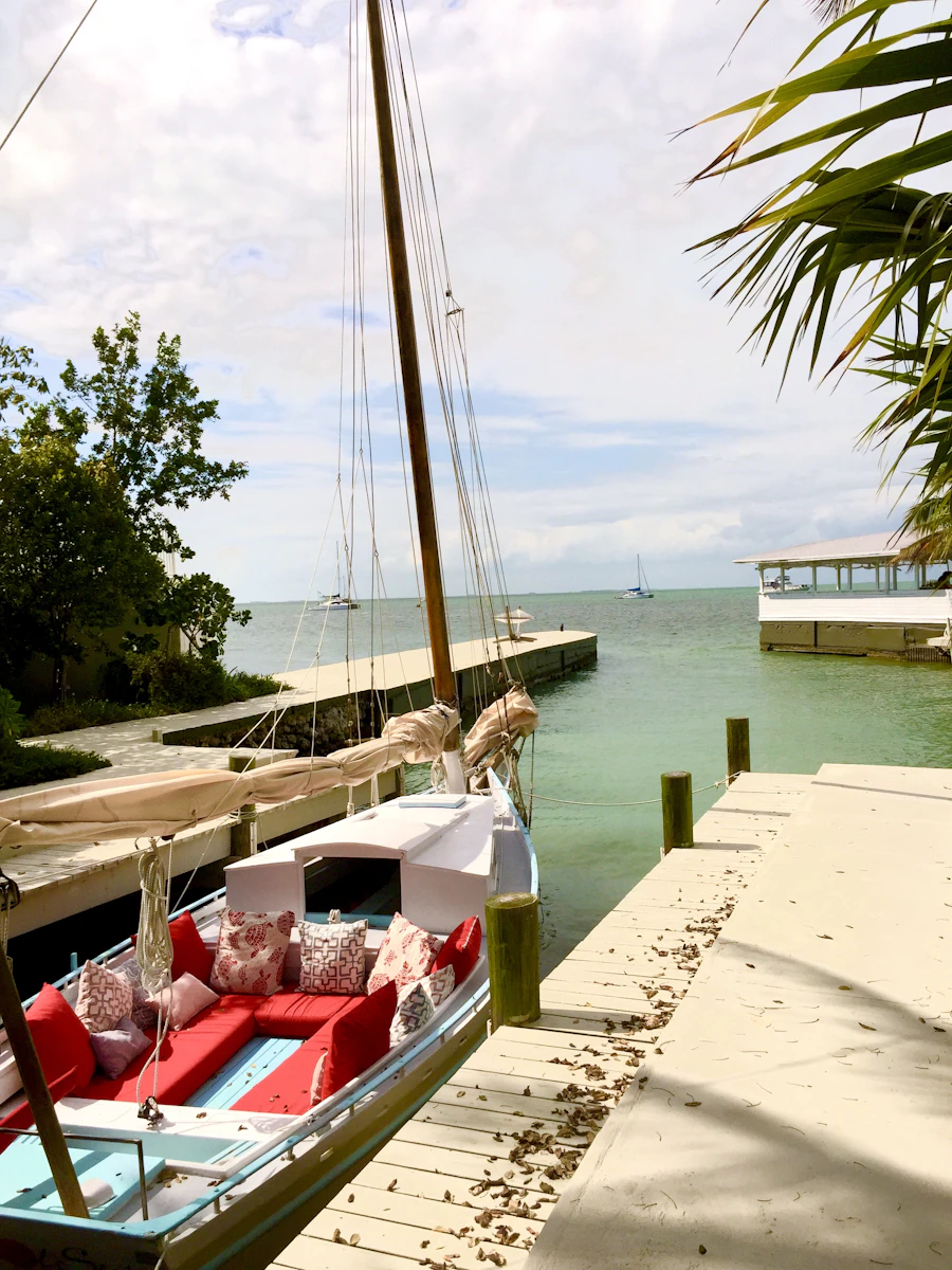 A boat moored at a private dock on a calm Florida waterway framed by palm fronds