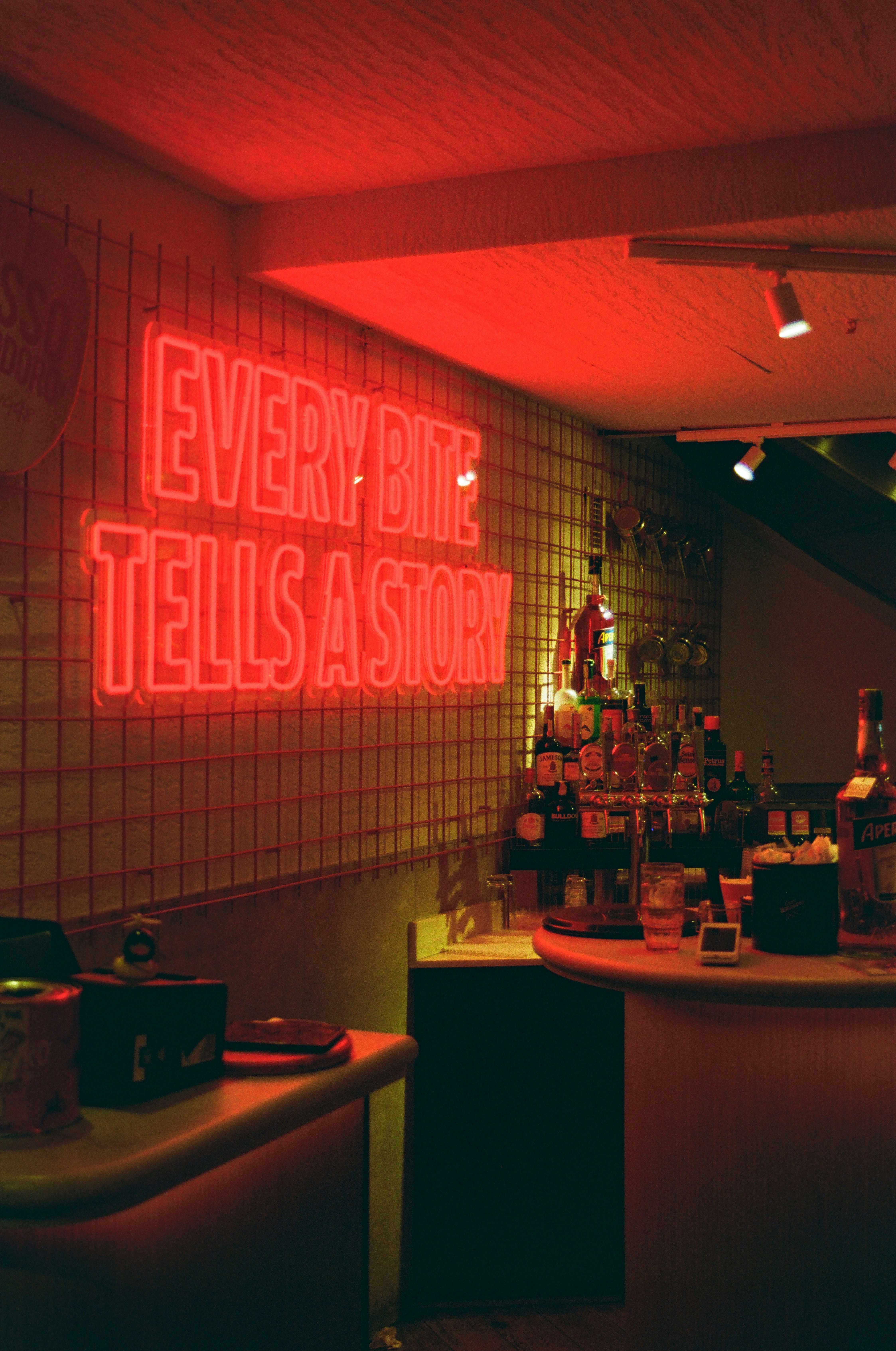 Neon sign reads "every bite tells a story".