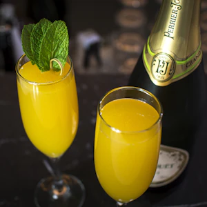 A mimosa in a champagne flute with orange