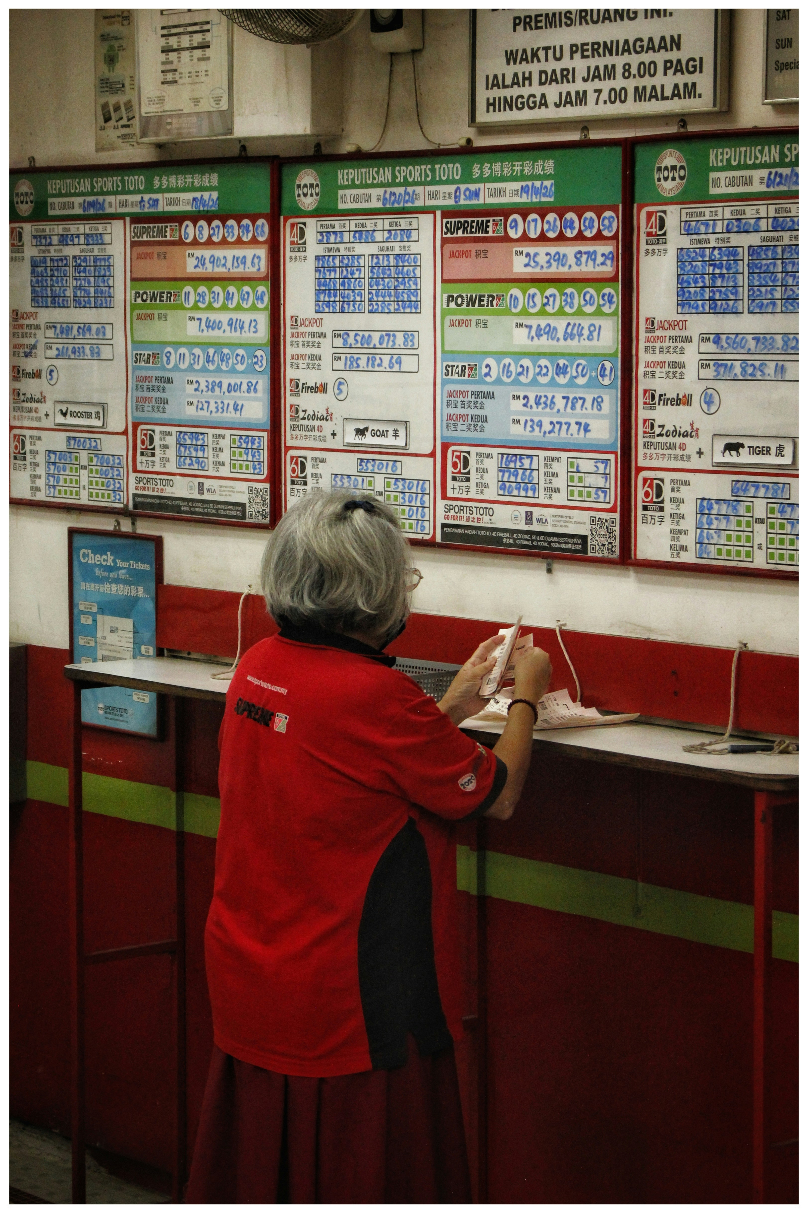 Woman in red shirt checks lottery results