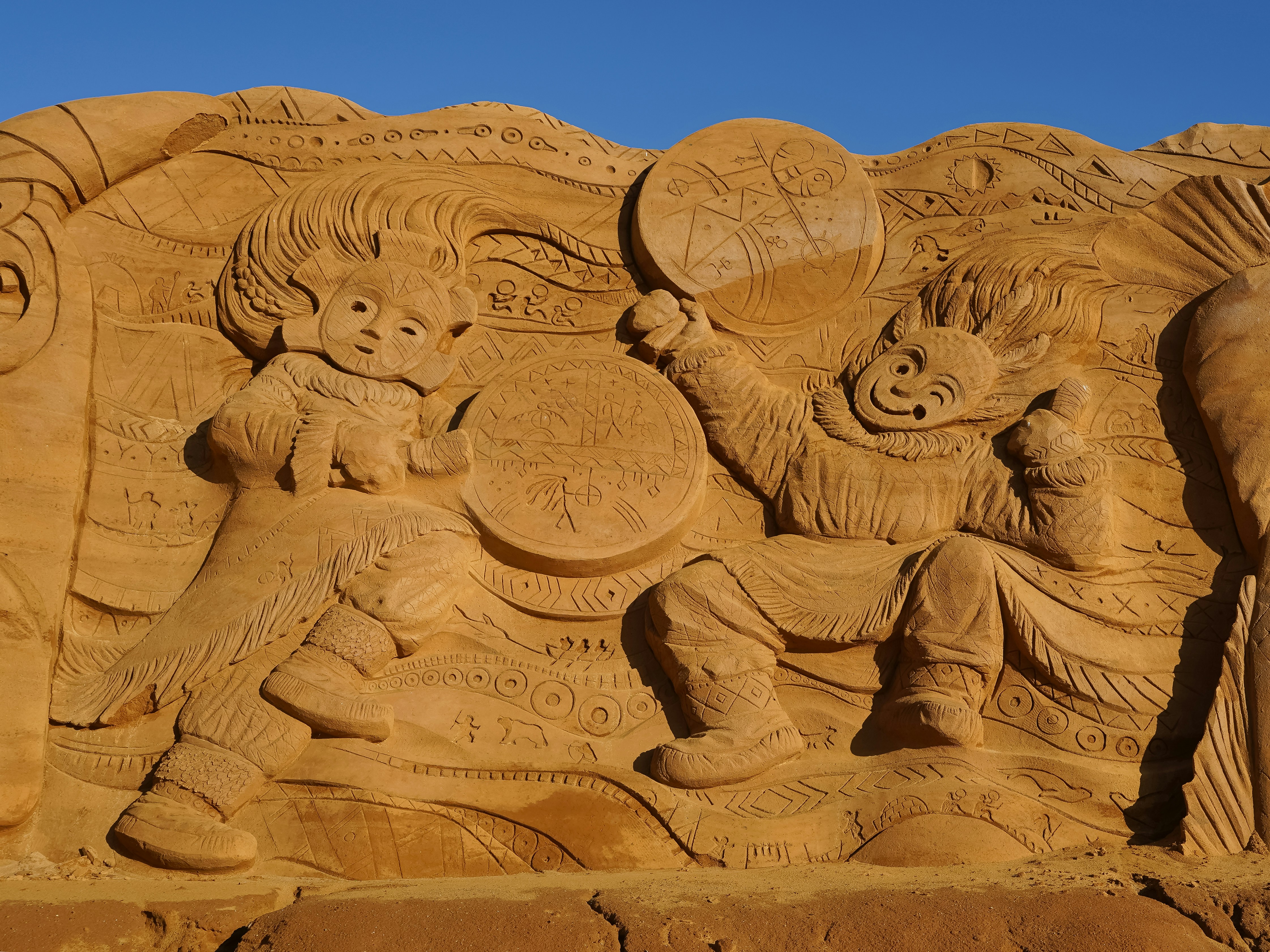 Escultura de arena de dos figuras tocando tambores