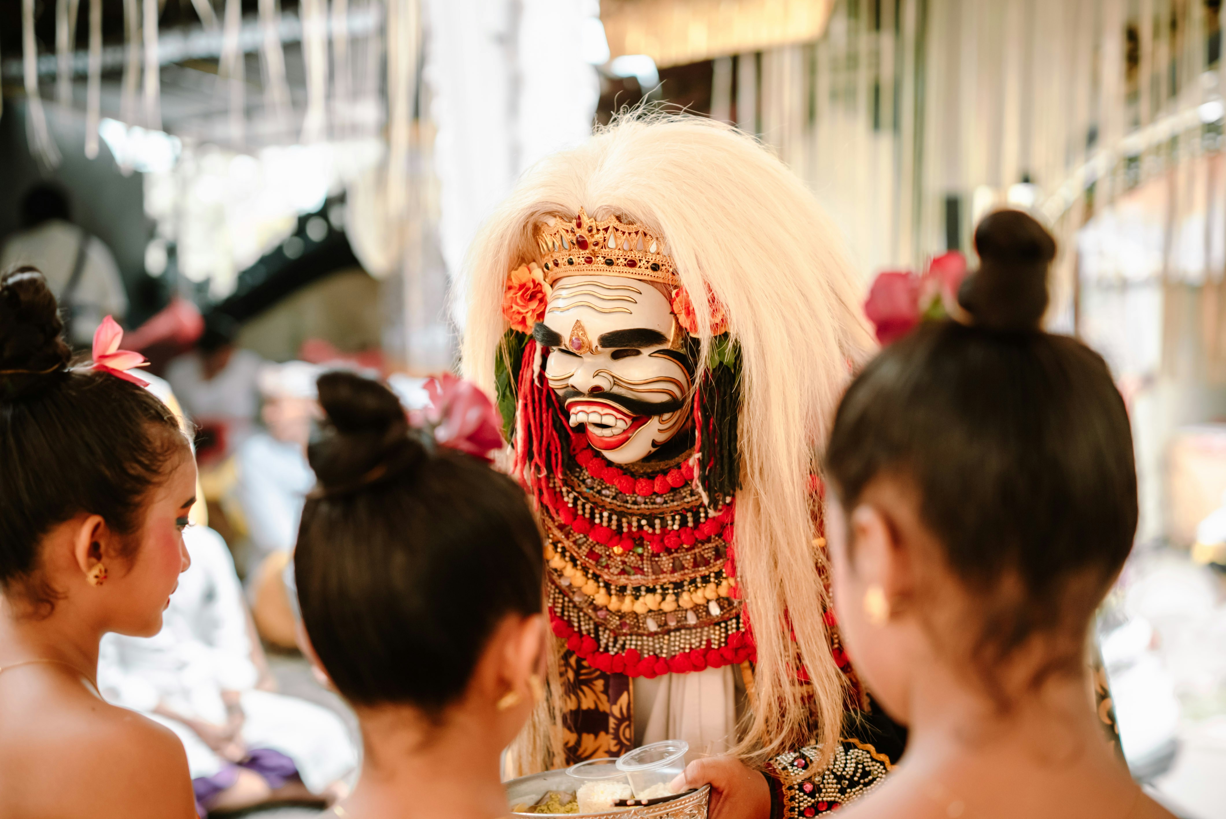 A performer in elaborate costume interacts with children.