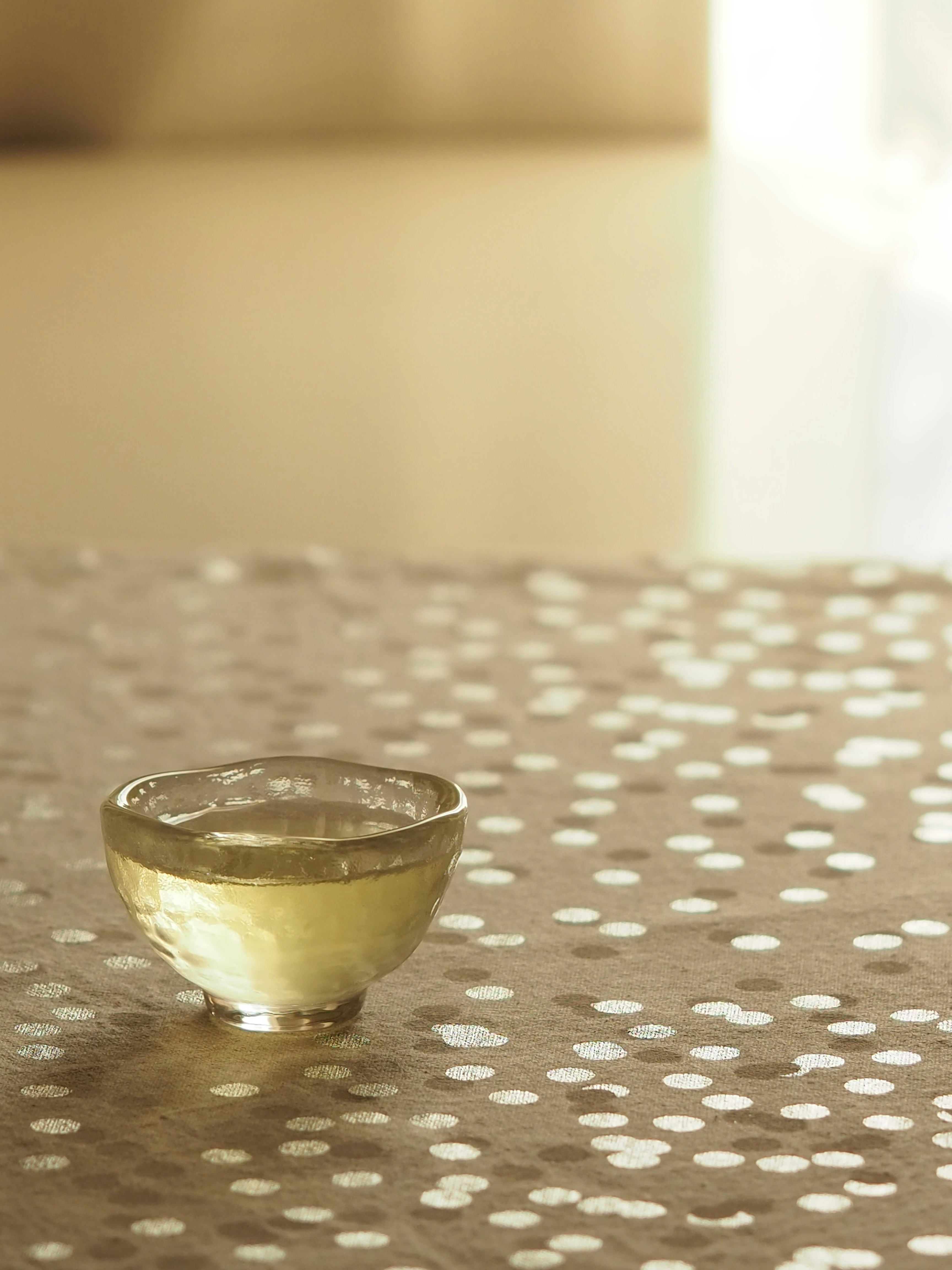 A small golden cup on a patterned surface