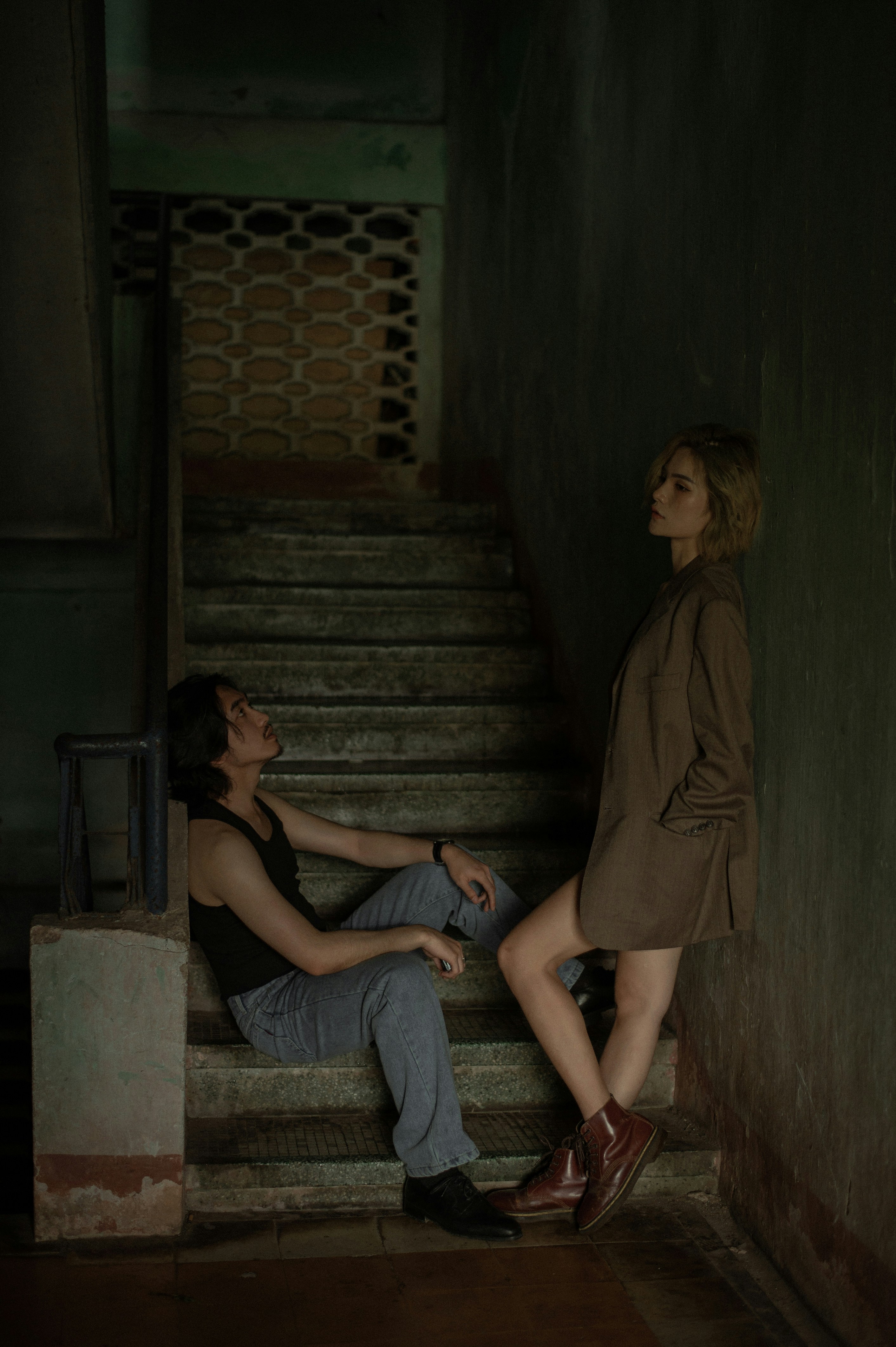 Photo of A man and woman on old, dark stairs. by Bin Thieu