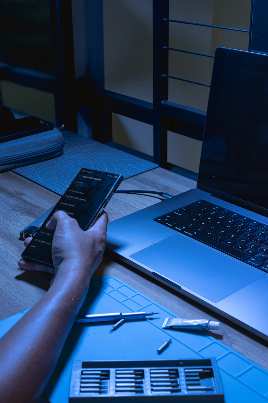 Developer using a smartphone alongside a laptop