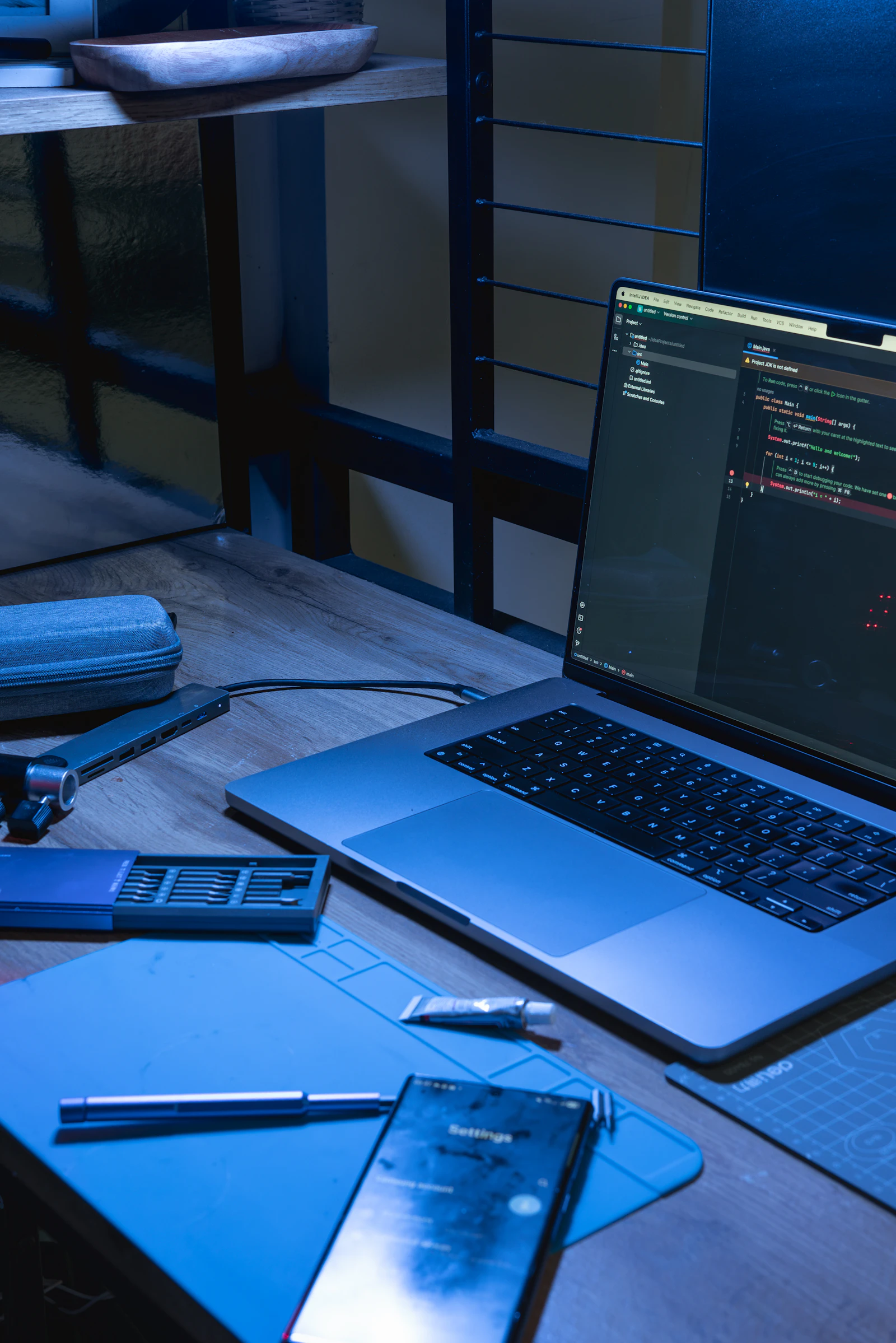 Laptop and phone on a desk with coding software open