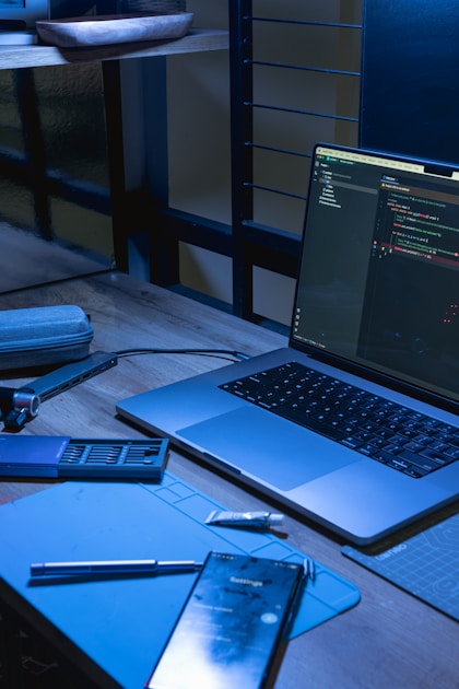 Laptop dan ponsel di atas meja kerja dengan layar menampilkan antarmuka aplikasi bisnis modern