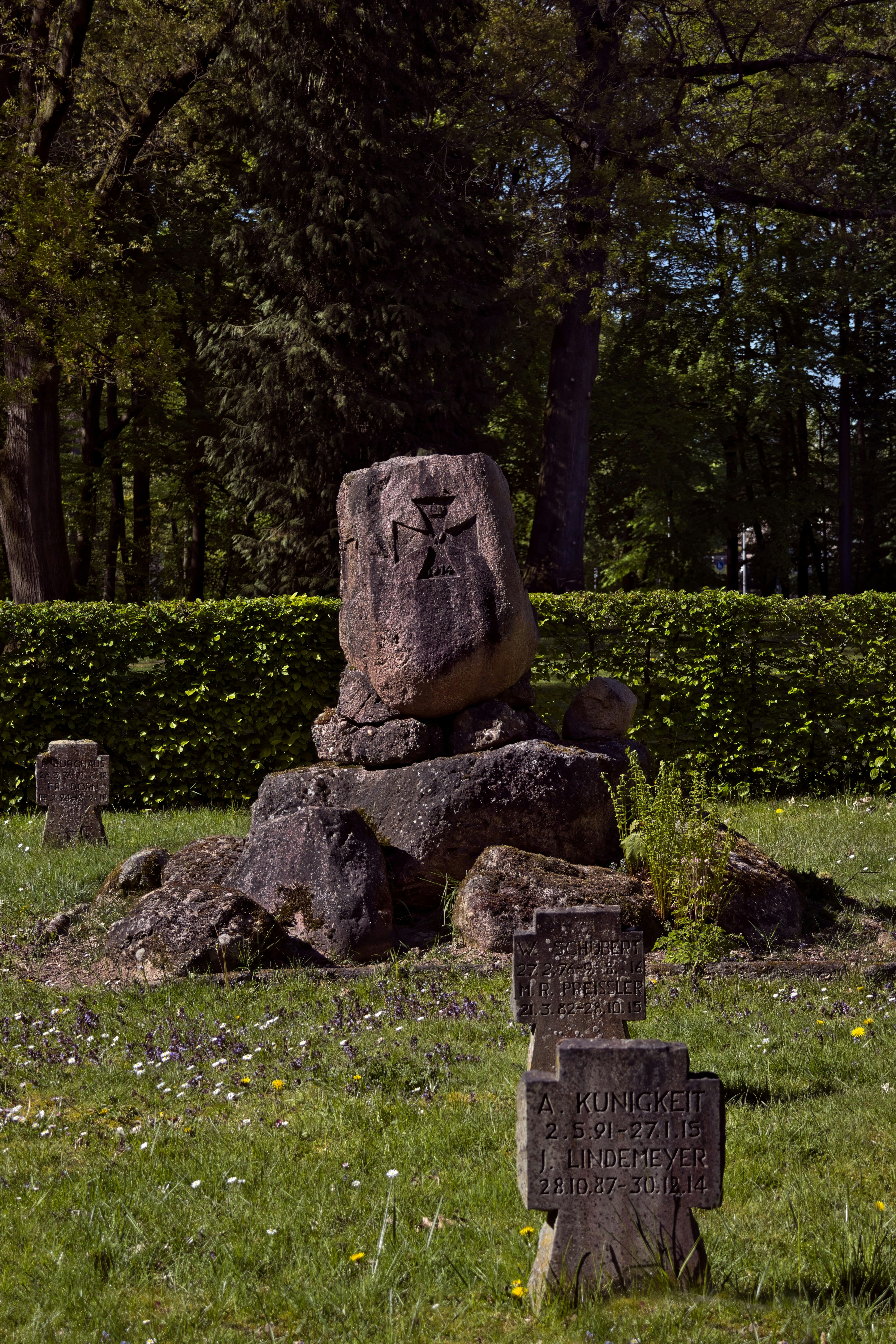 Monumento de piedra y cruces en un campo de hierba.