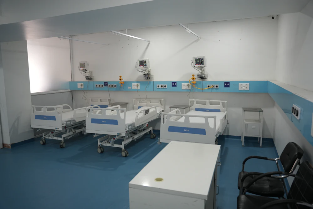 A hospital room with beds and wall-mounted monitoring equipment
