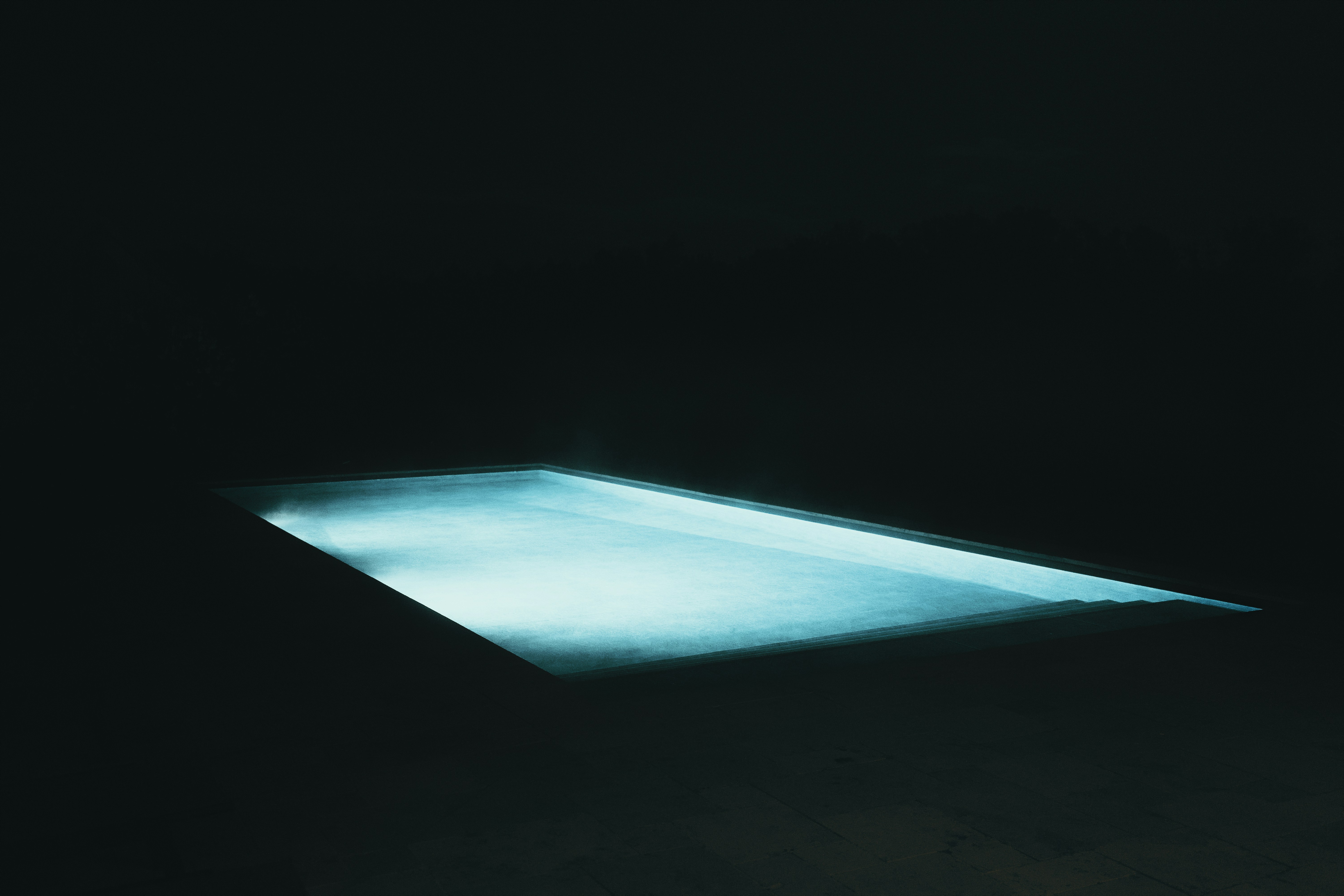 Uma piscina azul brilhante à noite