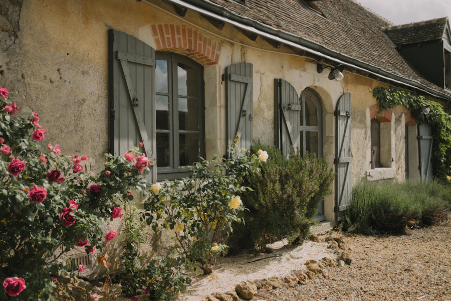 Petite maison de vacances en pierre avec des roses et des volets