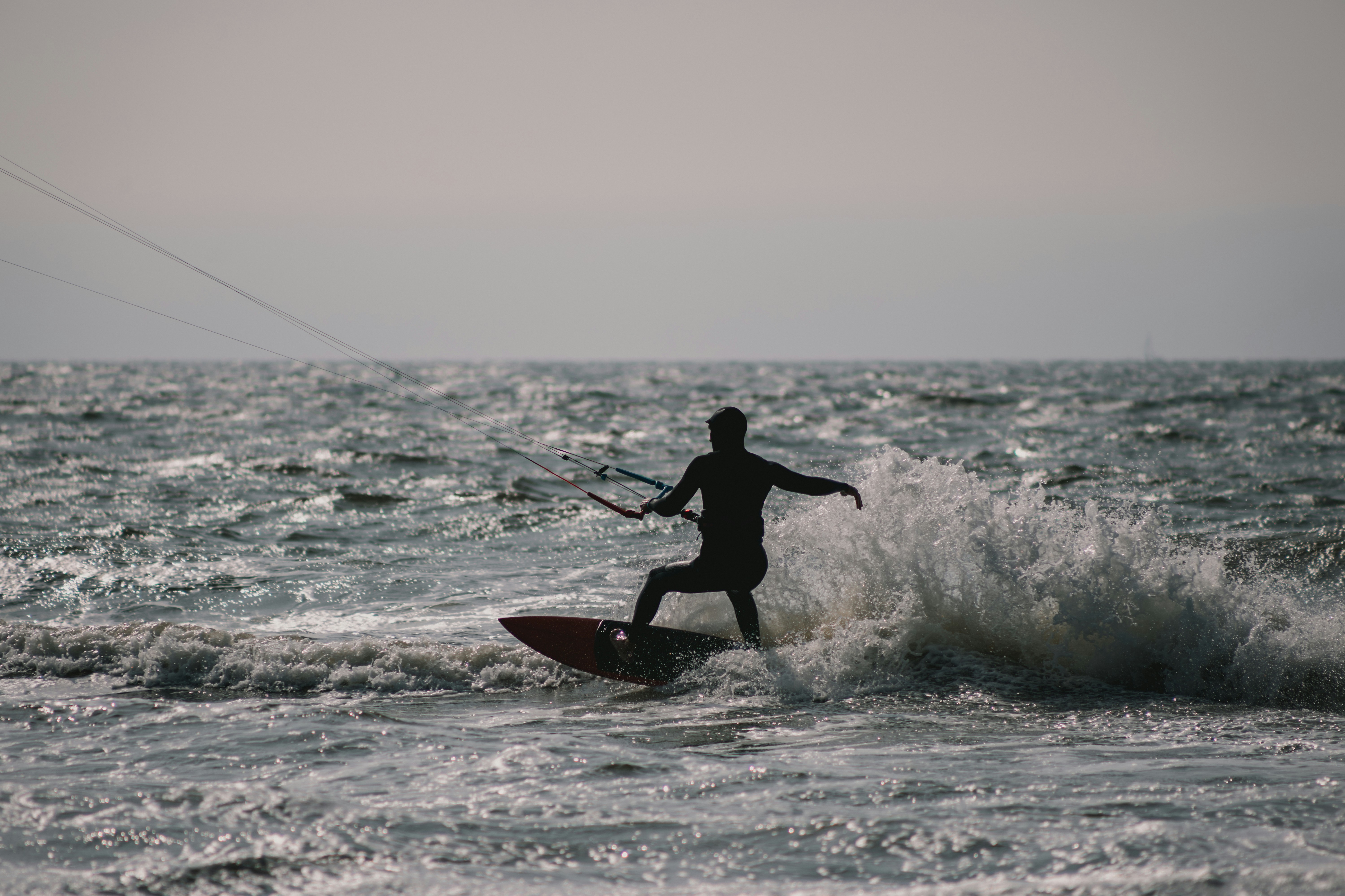 Person kitesurfing on a choppy ocean wave