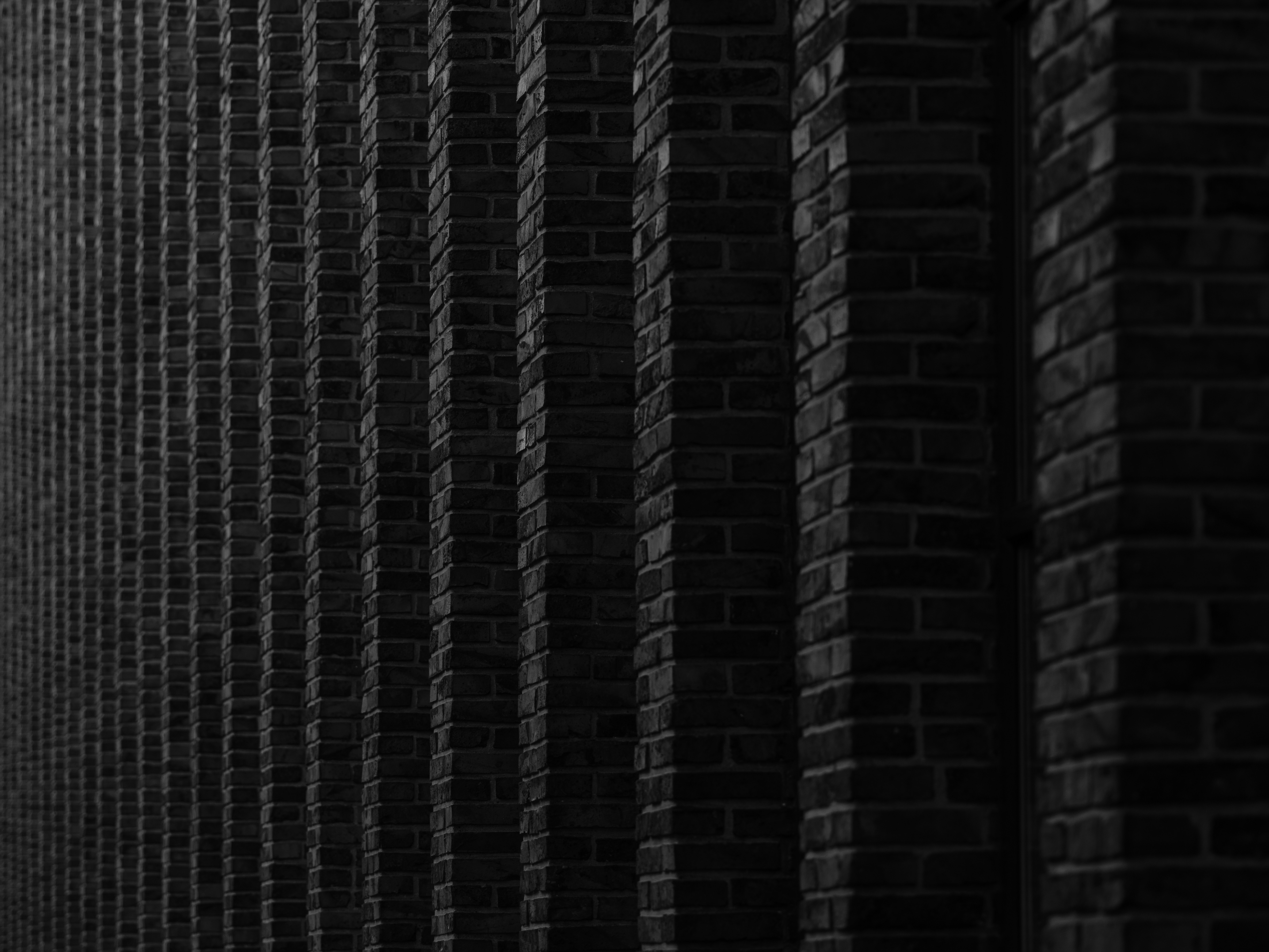 Muro de tijolos escuros com colunas verticais