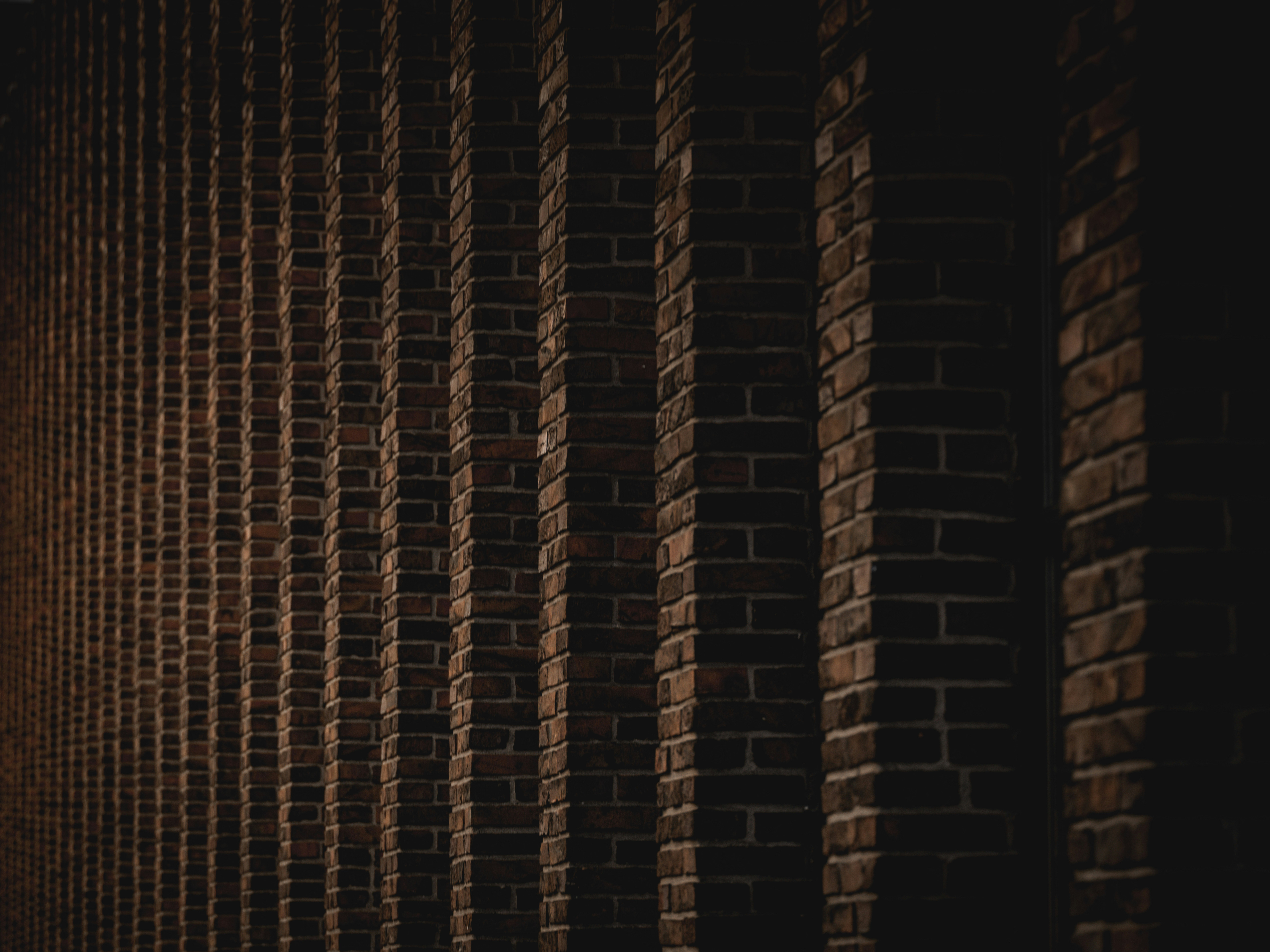 Muro de tijolos escuros com linhas verticais