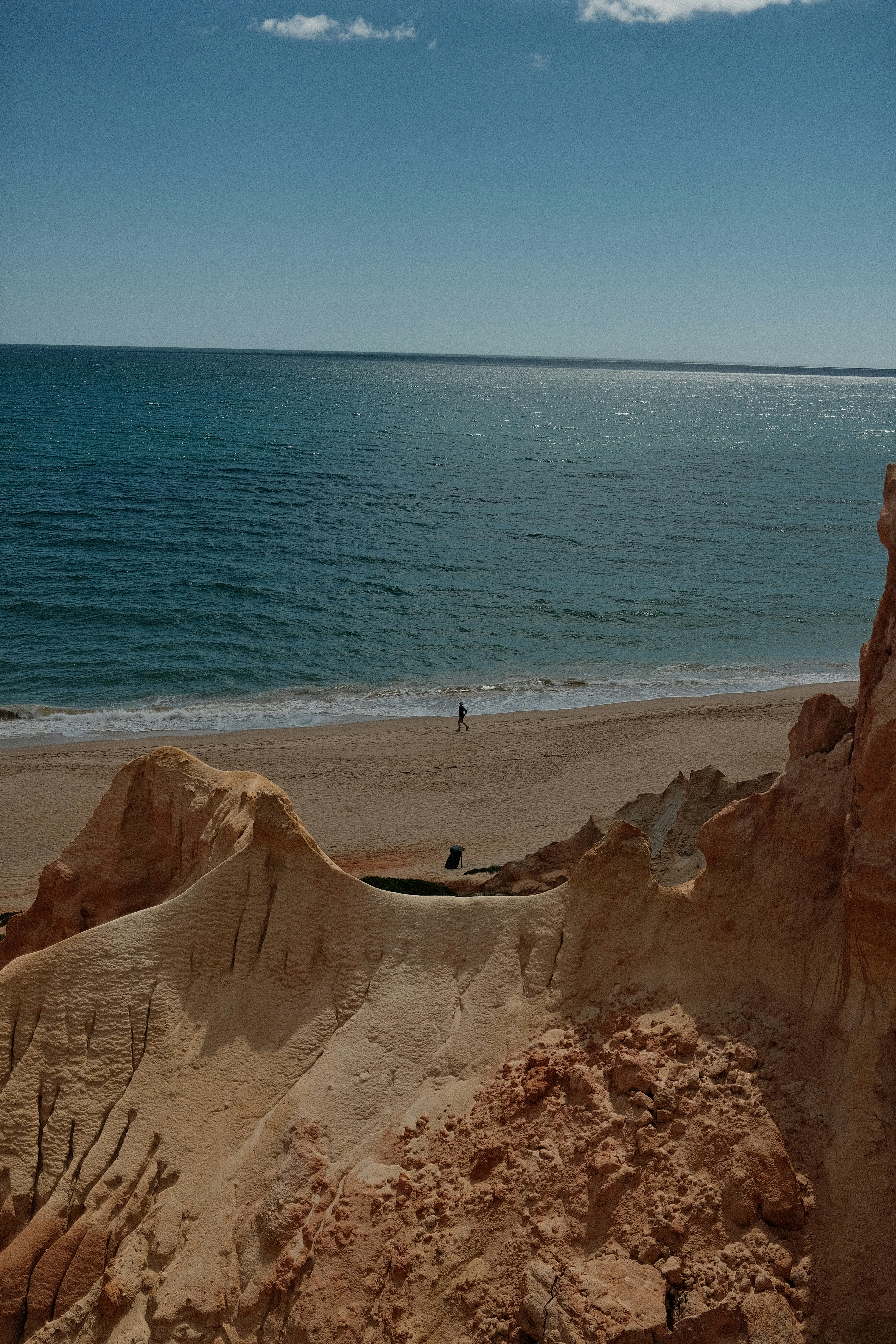 Sandy beach with ocean waves and rocky cliffs