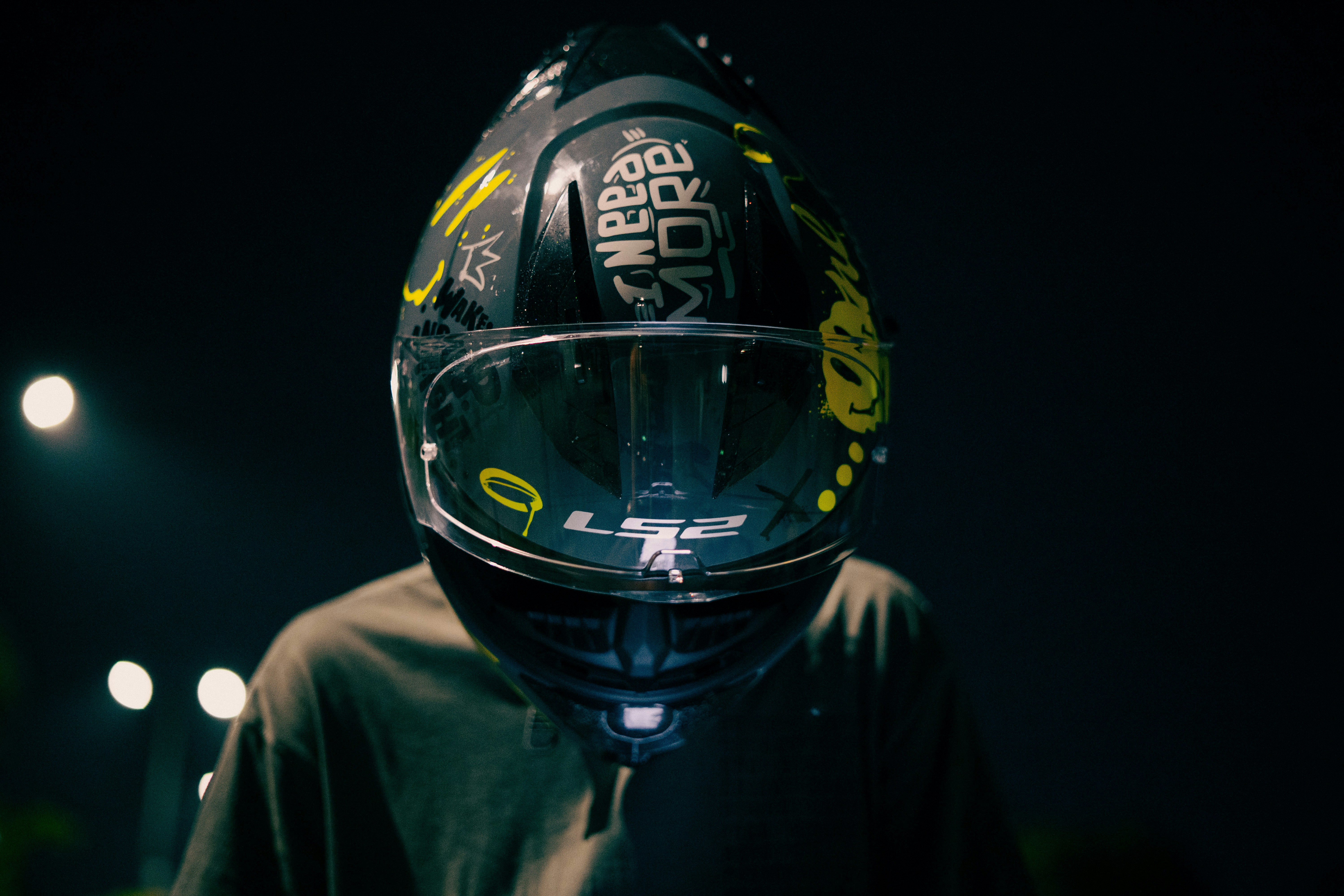 Person wearing a decorated motorcycle helmet at night.