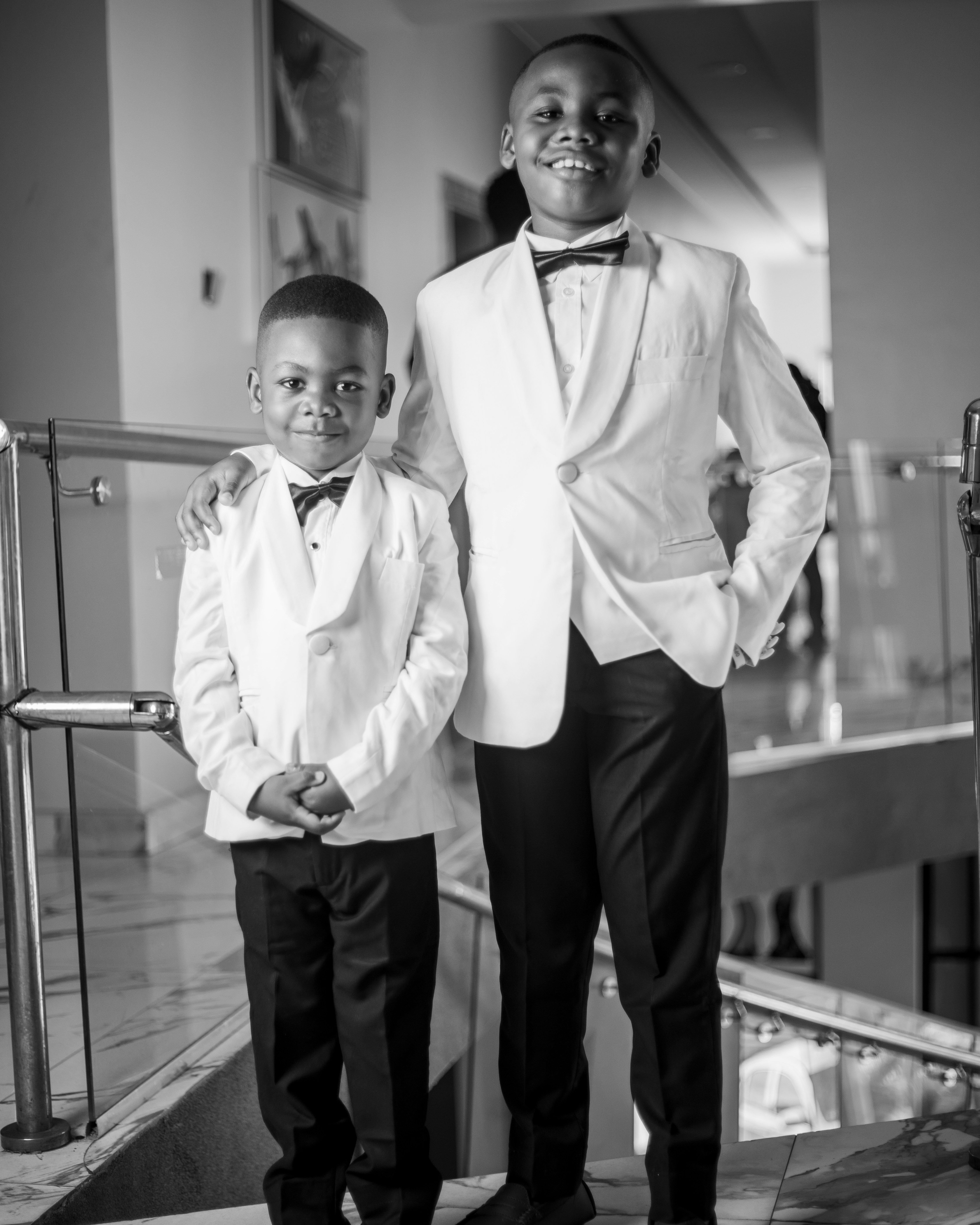 Two young boys in formal white suits