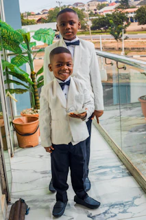 Two young boys in formal wear standing together.