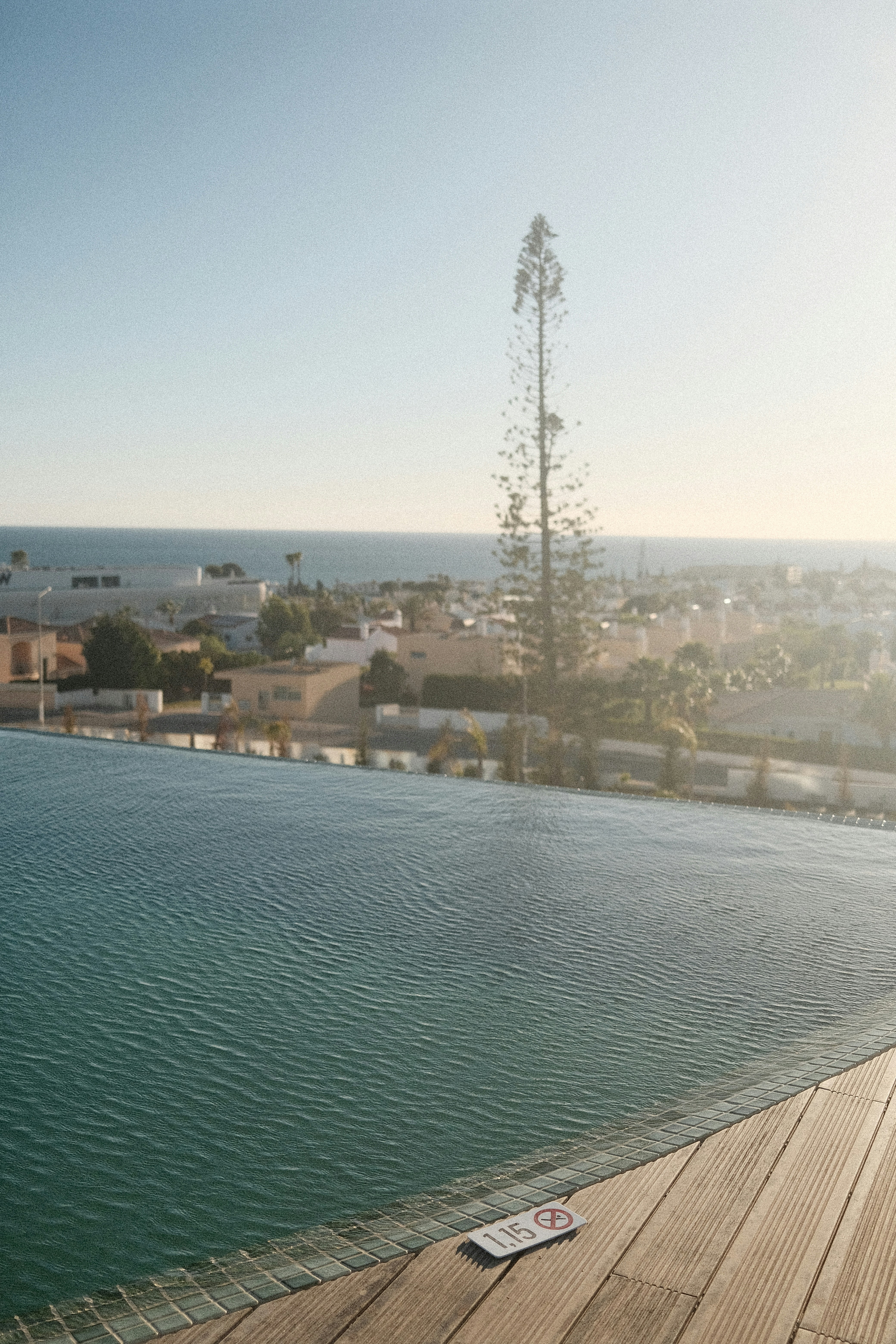 Infinity pool overlooking a coastal town at sunset